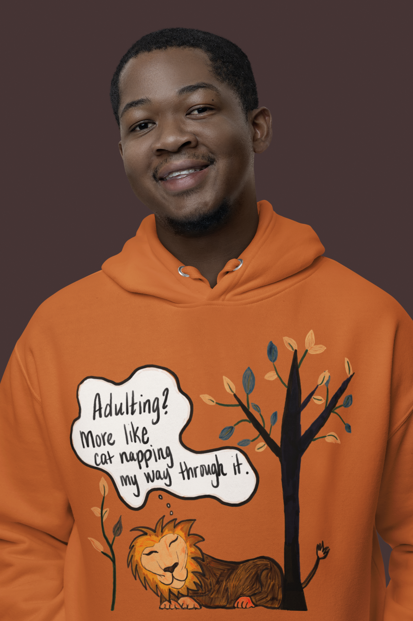 Man wearing adobe orange Adulting Nap Lion hoodie smiling – sarcastic lazy vibes affirmation by GrungePup Sarcastic Affirmations