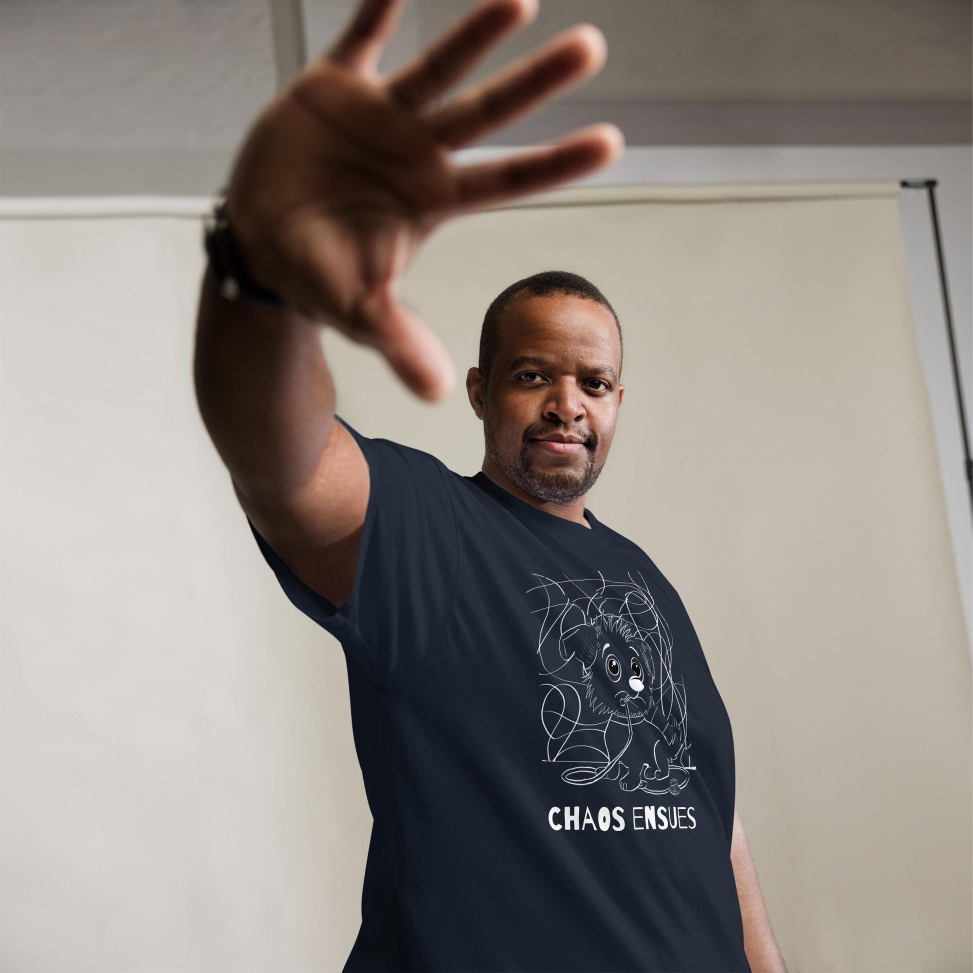 Man wearing navy Chaos Ensues white ink t-shirt with chaotic vet dog design – GrungePup Vet Chaos humor apparel for vet techs