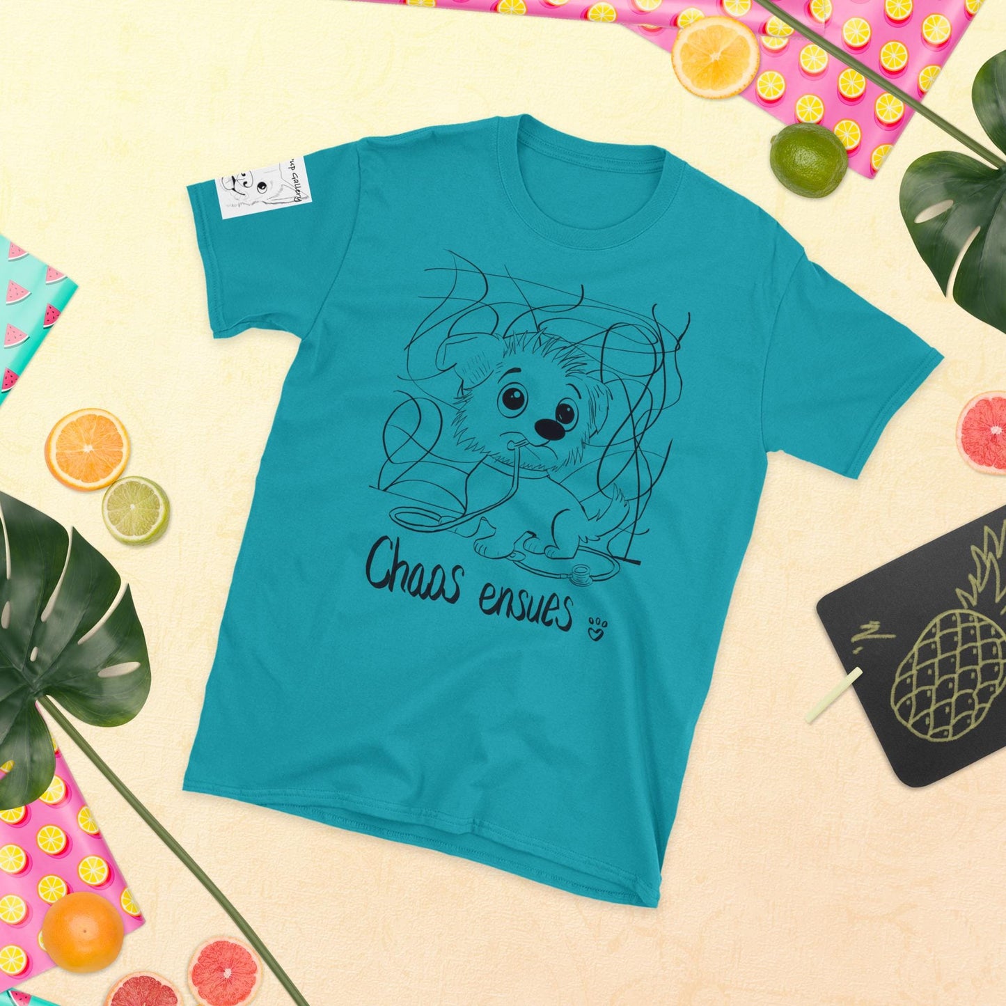 Chaos Ensues teal t-shirt with funny chaotic vet dog design on colorful flat lay background – GrungePup Vet Chaos apparel