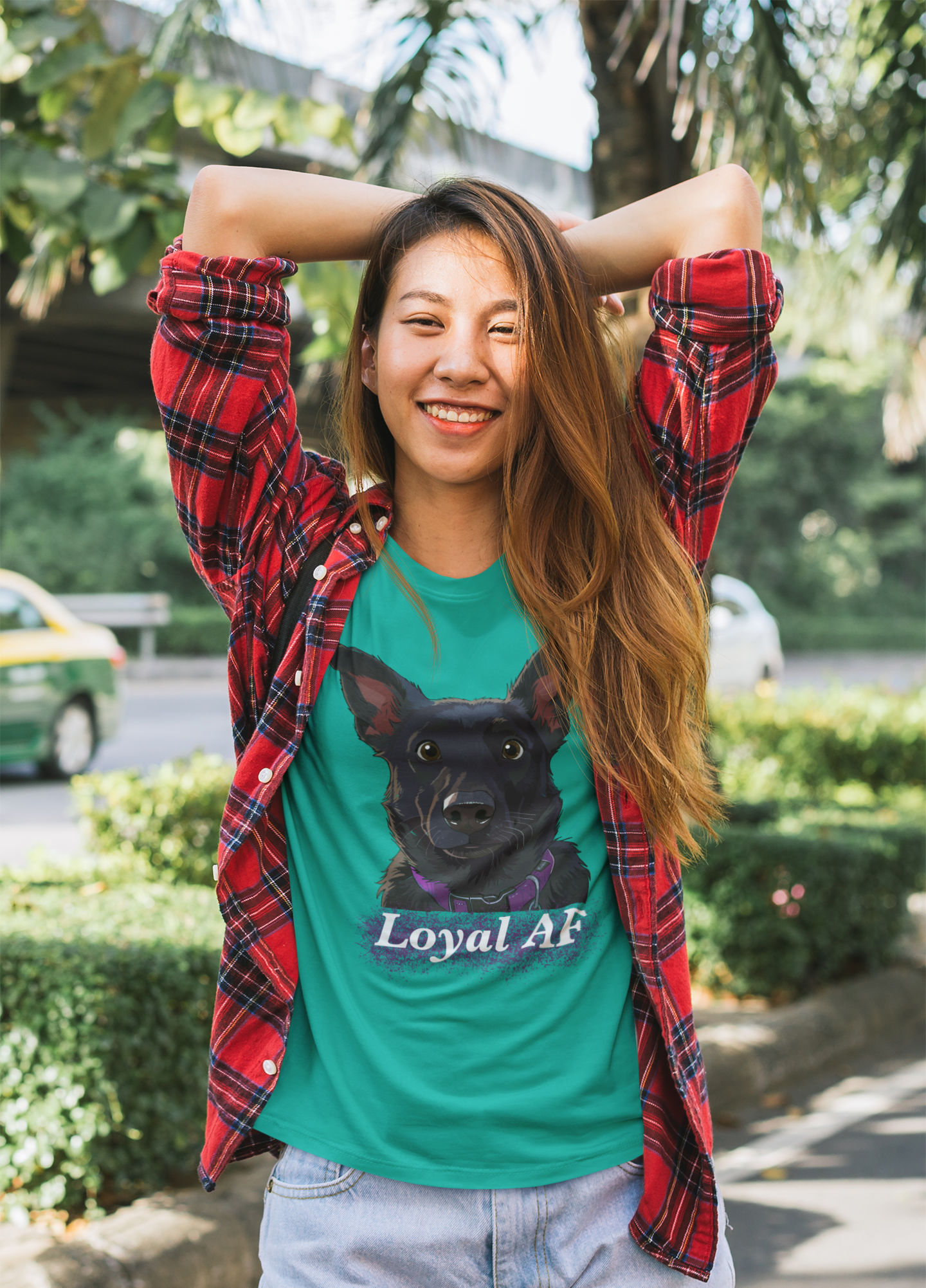 Cheerful woman smiling and posing on street wearing a jade green t-shirt featuring Mathis Loyal AF design