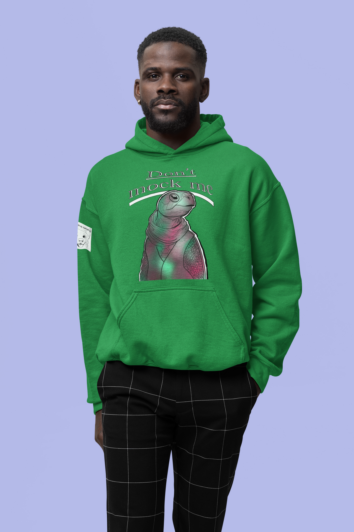 Man standing in a studio wearing an Irish green Gildan hoodie with the Don’t Mock Me Mock Turtle design