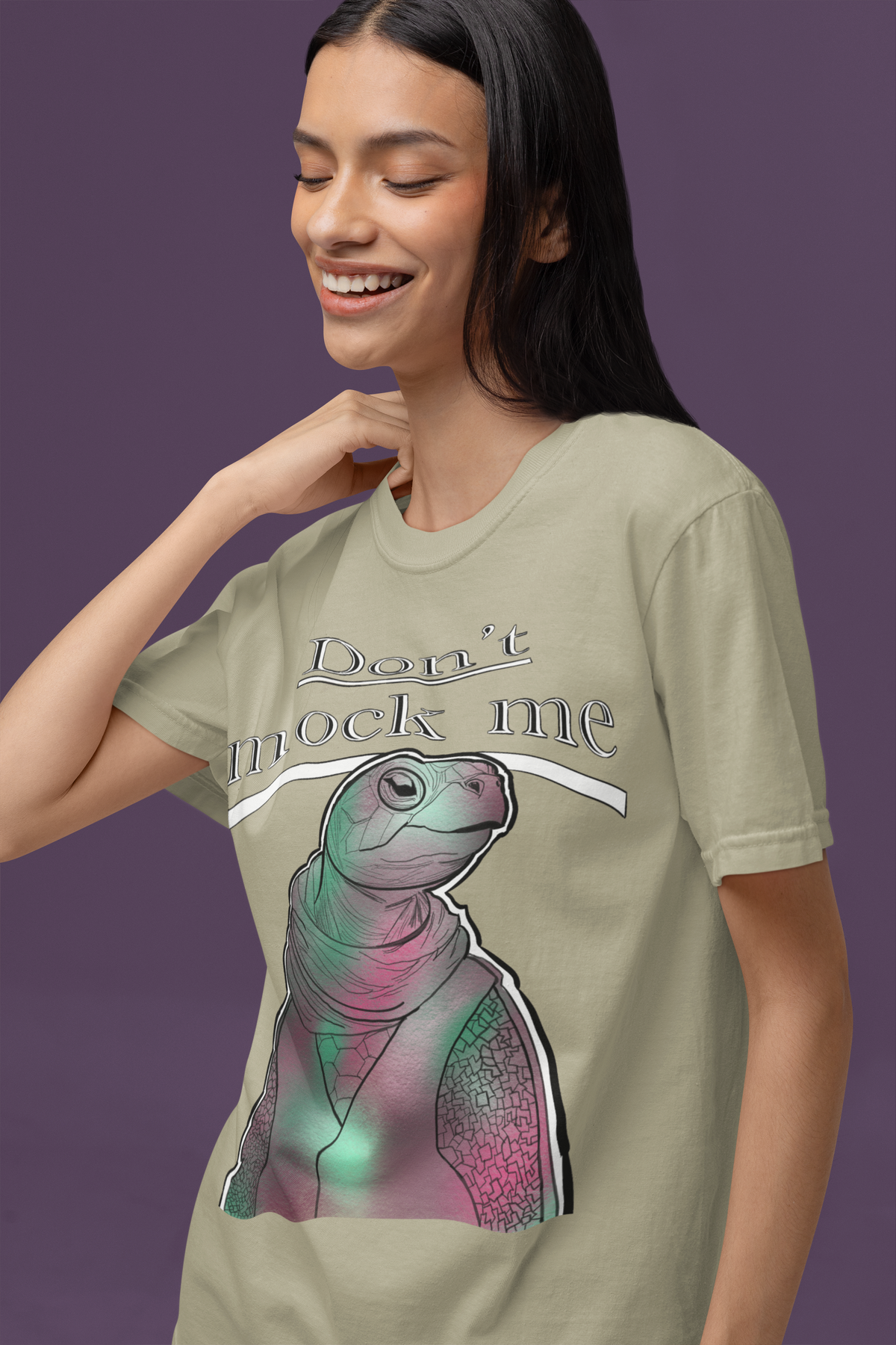 Happy woman smiling and touching her hair while wearing a khaki Comfort Colors 1717 t-shirt with the Don’t Mock Me Mock Turtle design