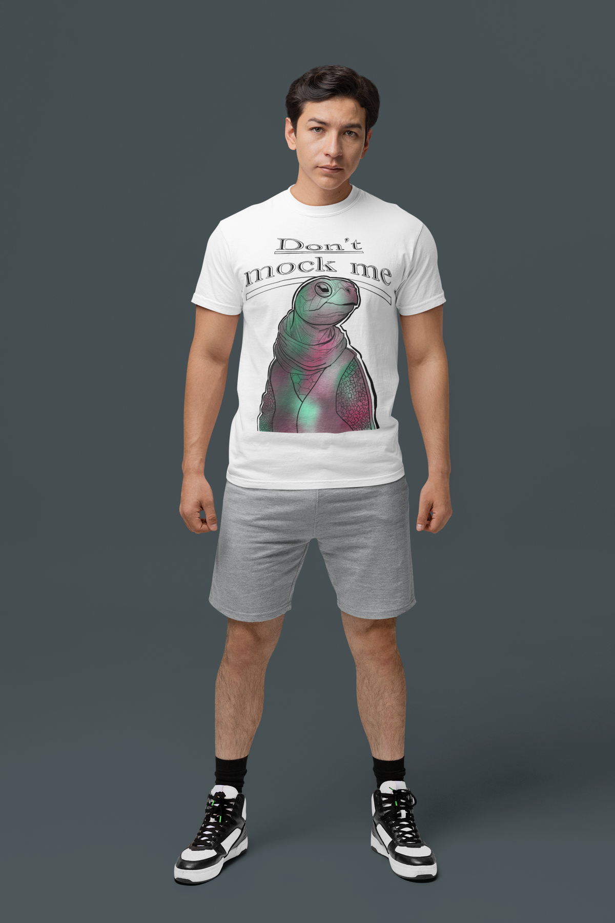 Young man standing in a studio wearing a white Comfort Colors 1717 t-shirt with the Don’t Mock Me Mock Turtle design