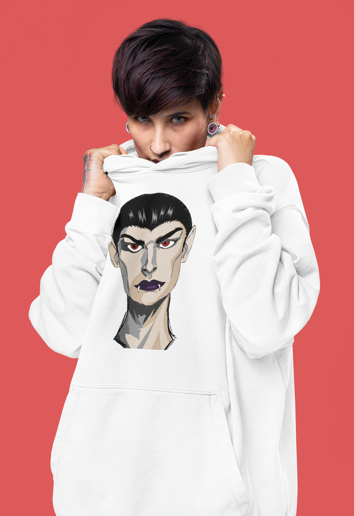 Tattooed woman pulling a white hoodie up toward her face, printed with the Emo Vamp vampire face against a red background.