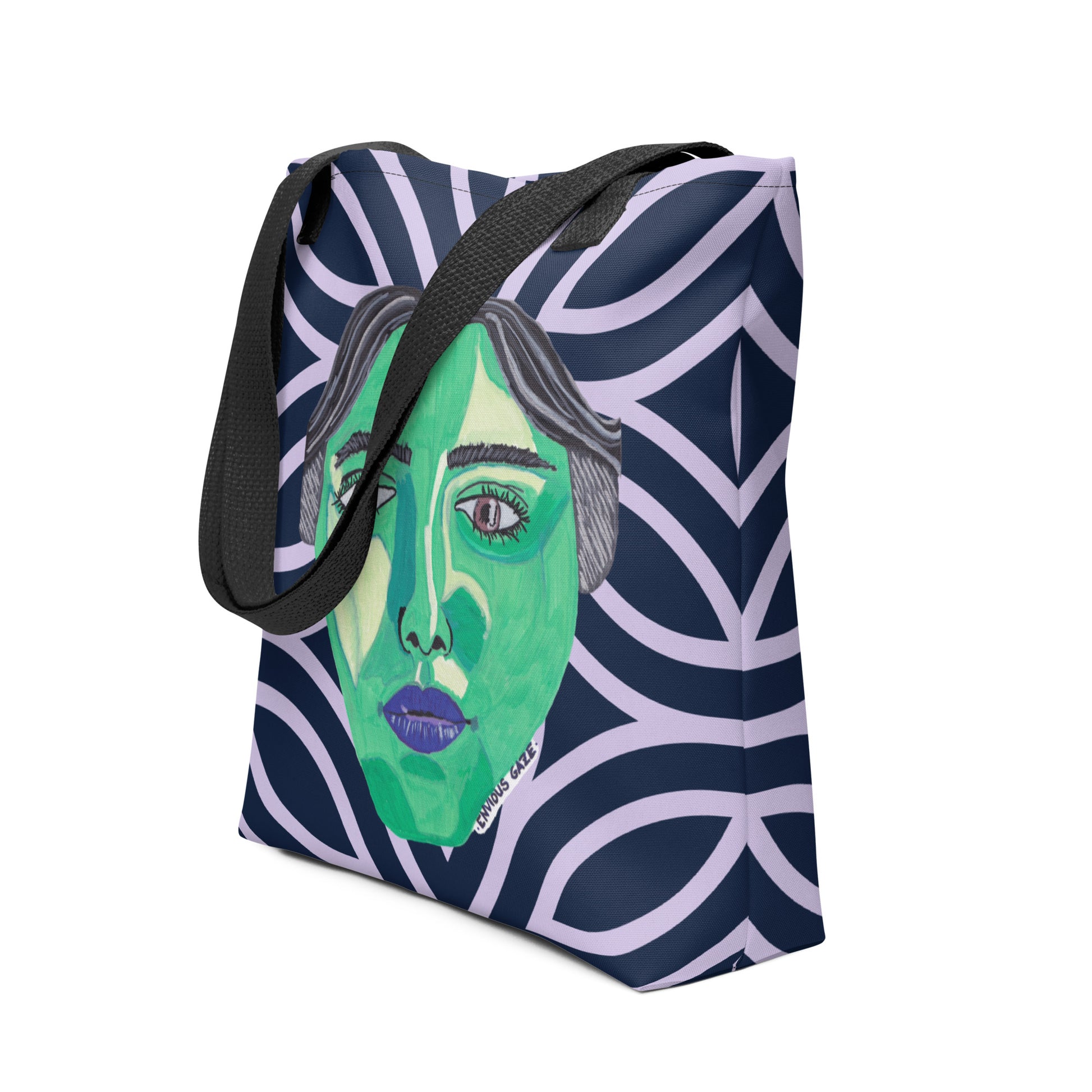 Side view of dark blue geometric Envious Gaze tote bag showing the full colorful face design and black straps
