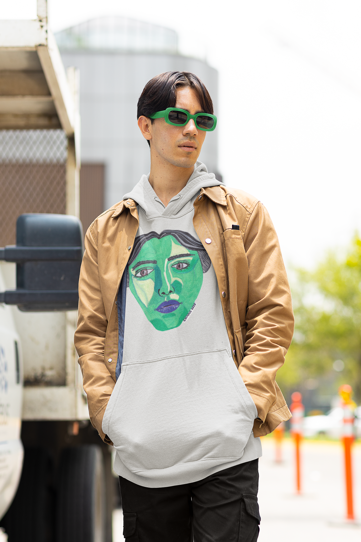 Man wearing ash gray Envious Gaze hoodie with colorful face art and green sunglasses