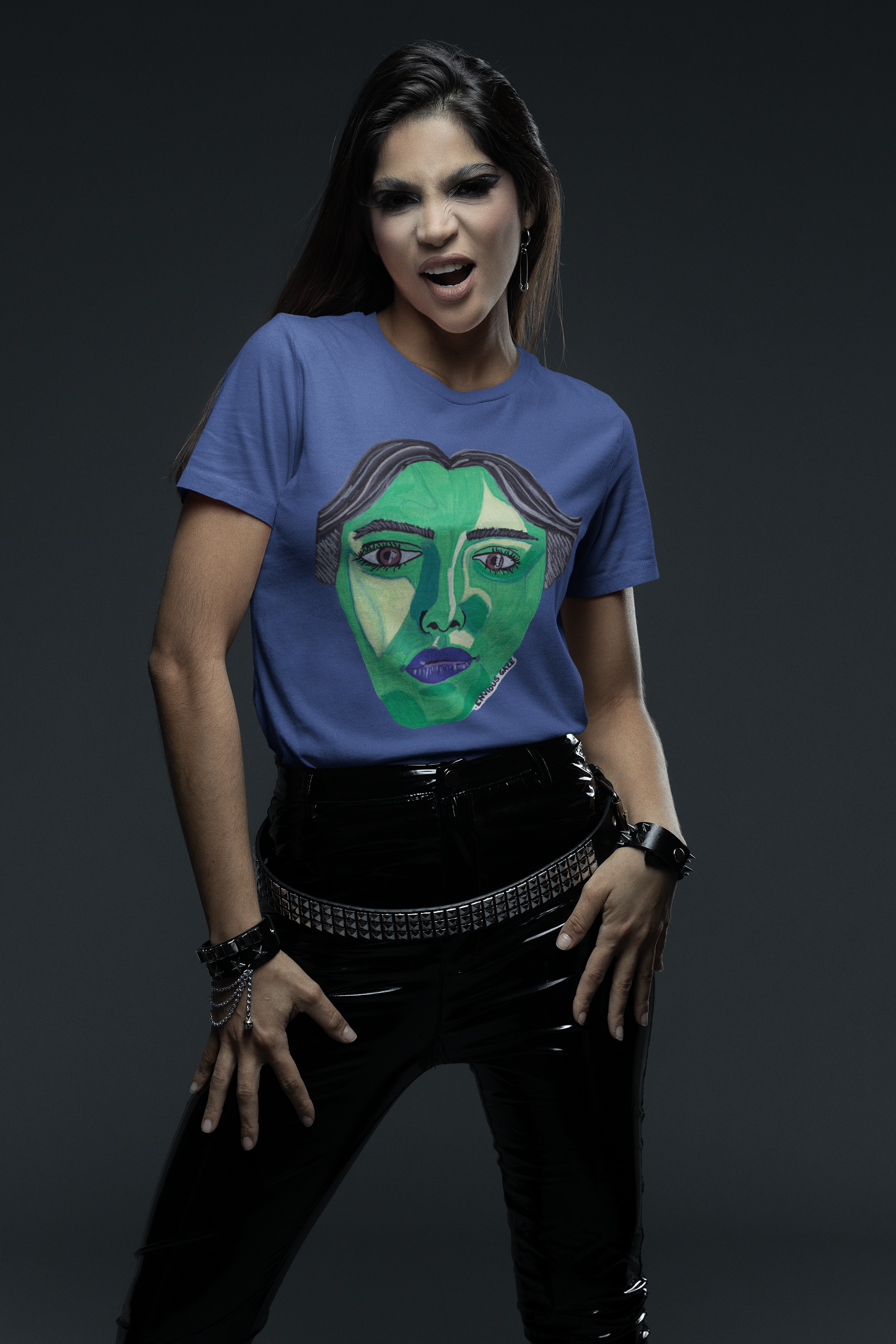Woman in rocker style wearing heather true royal Envious Gaze t-shirt with green face design
