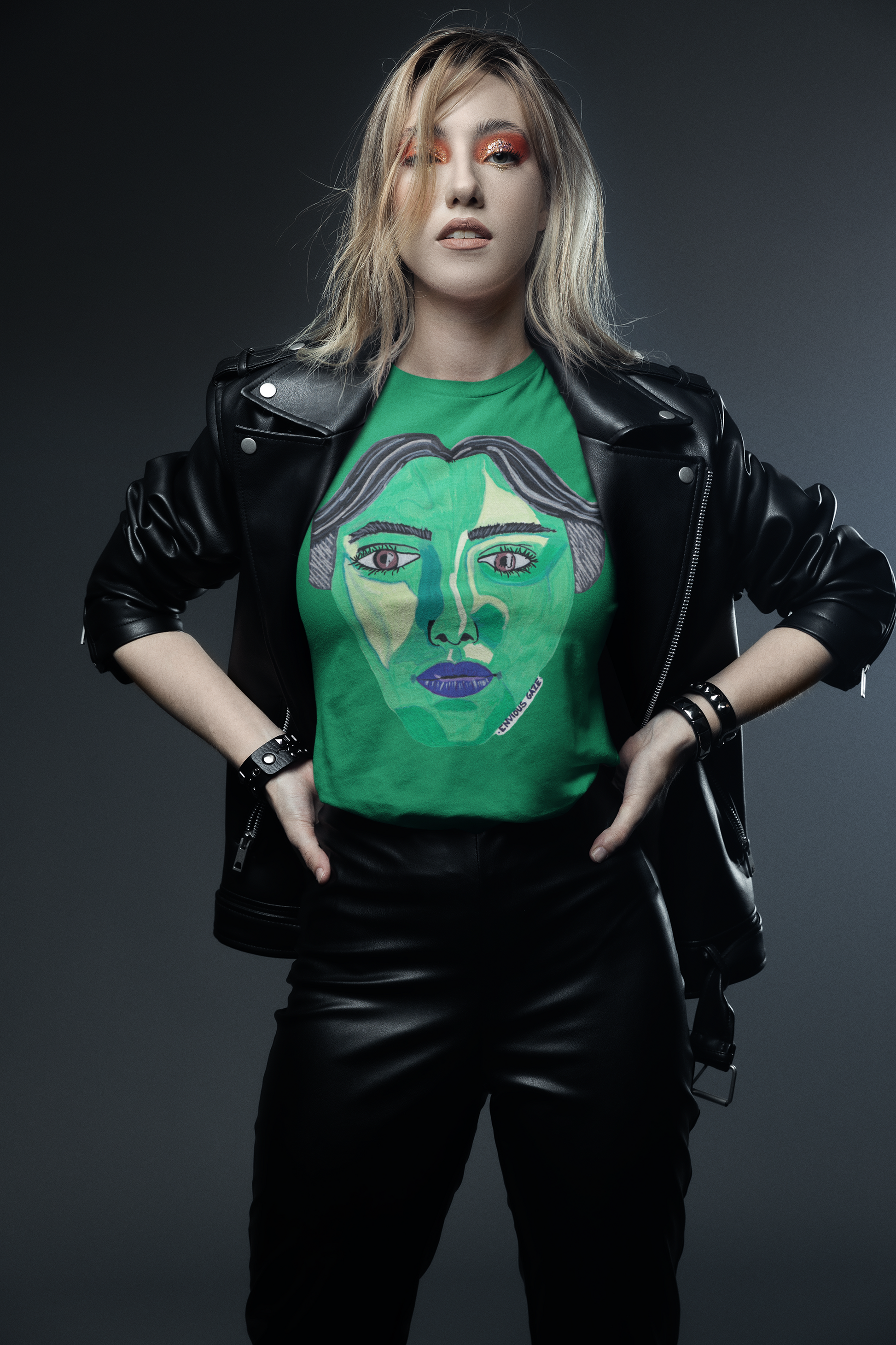 Blonde woman wearing kelly green Envious Gaze t-shirt with bold green face artwork