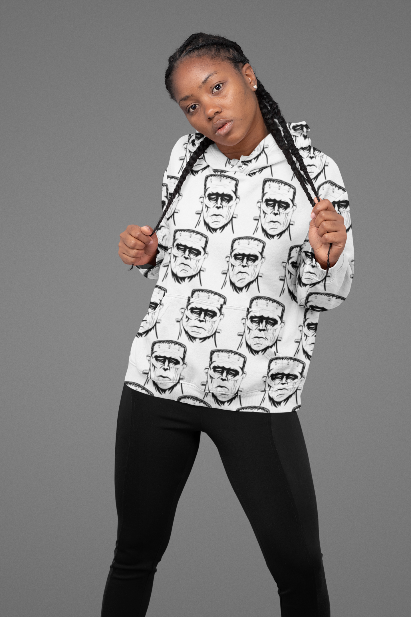 Woman with braids wearing white Frank's Monster all-over print hoodie pulling the drawstrings