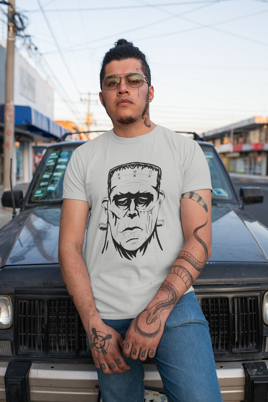 Tattooed man wearing athletic heather gray Frank's Monster t-shirt posing in front of a car