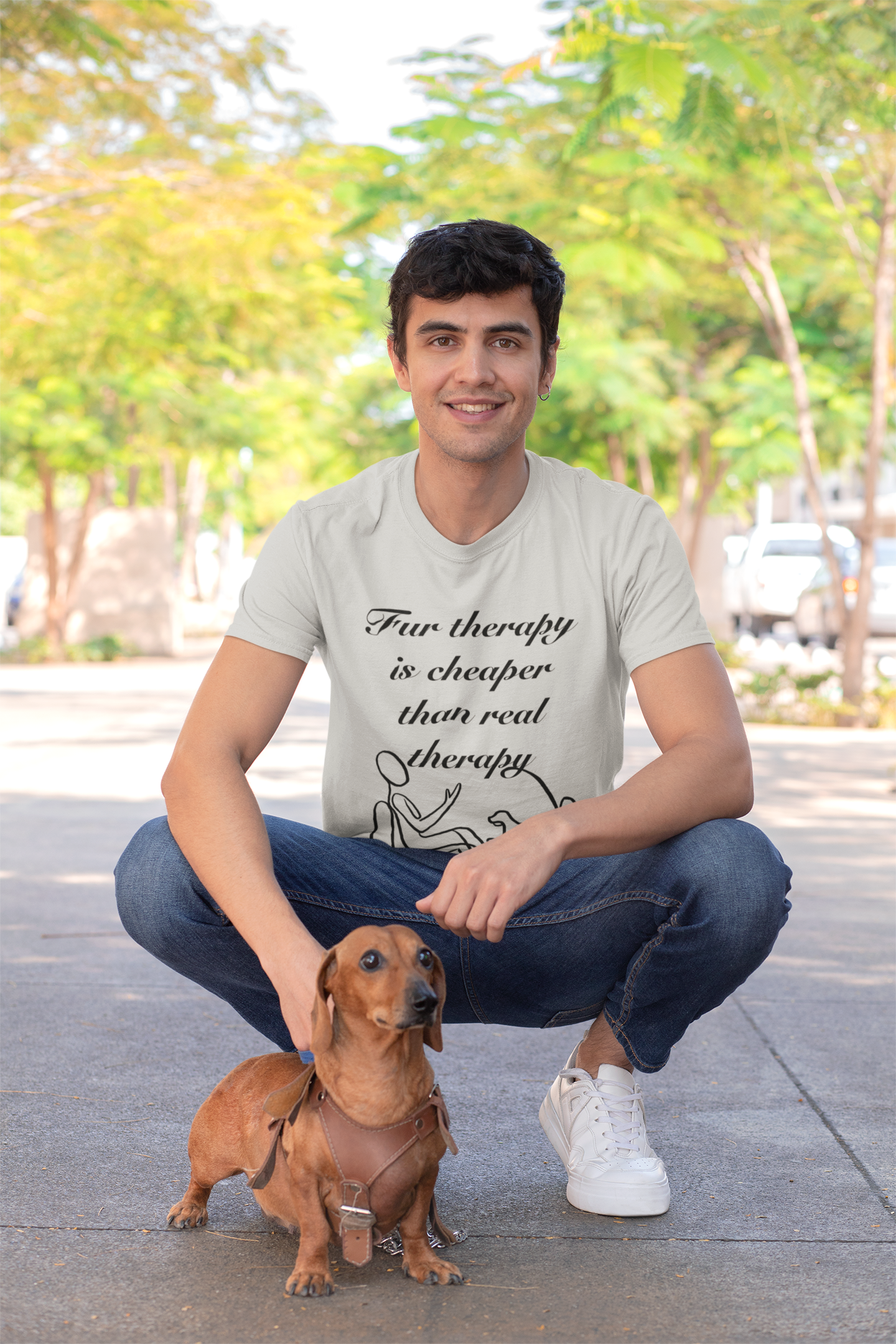 Man crouching and smiling with his dachshund while wearing athletic heather Fur Therapy t-shirt