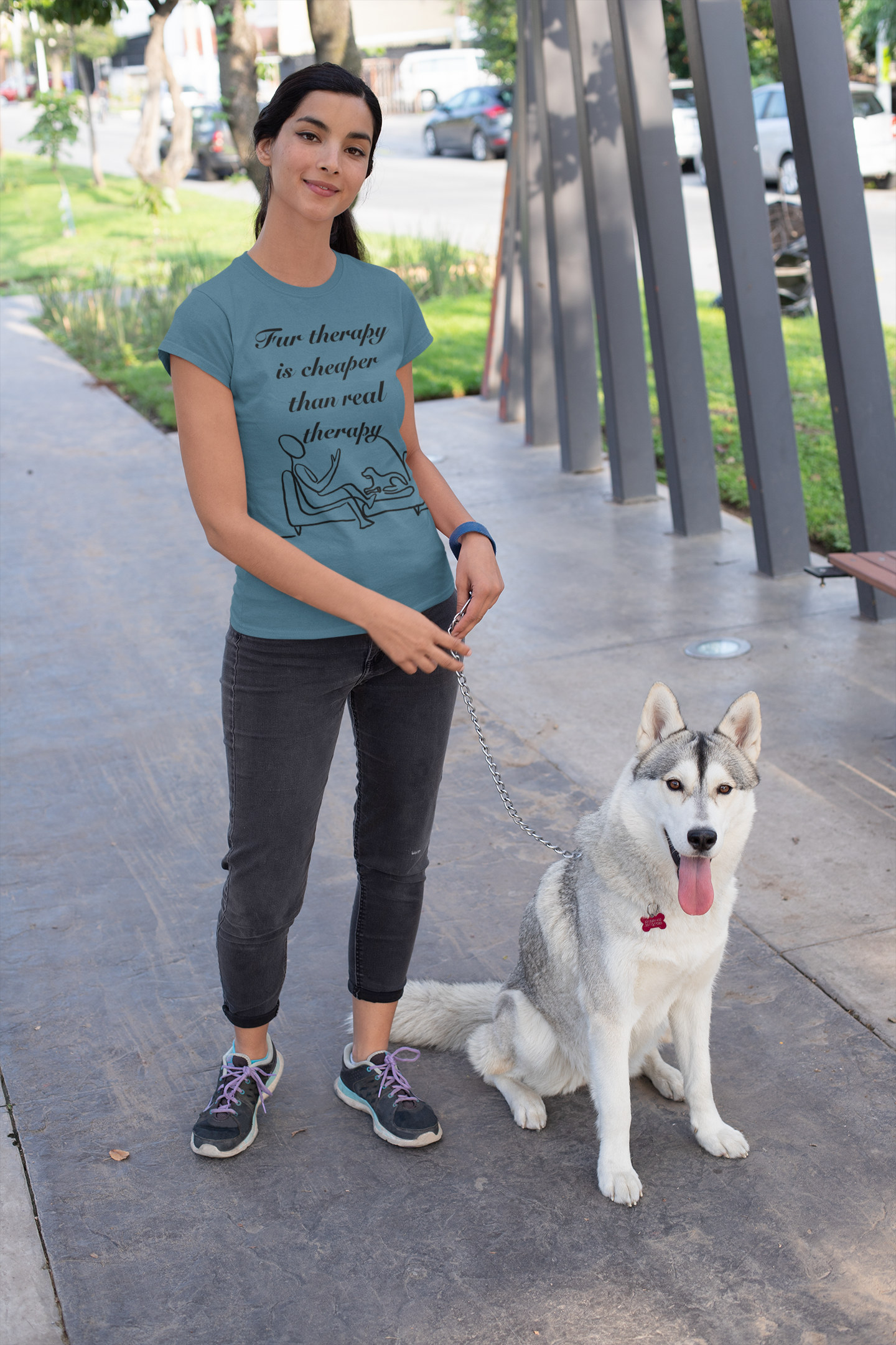 Woman standing outdoors holding leash of her husky while wearing heather deep teal Fur Therapy t-shirt