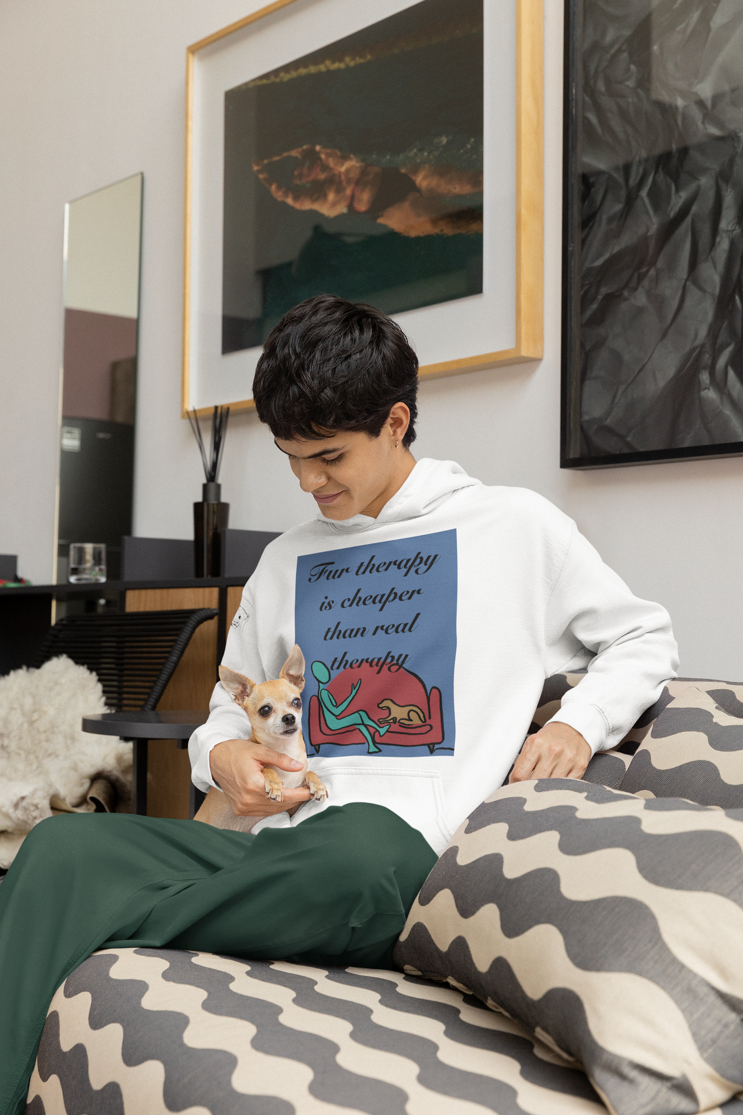 Man sitting on couch holding small dog wearing white Fur Therapy Is Cheaper Than Real Therapy colored dog hoodie – relatable pet therapy humor by GrungePup Sarcastic Affirmations