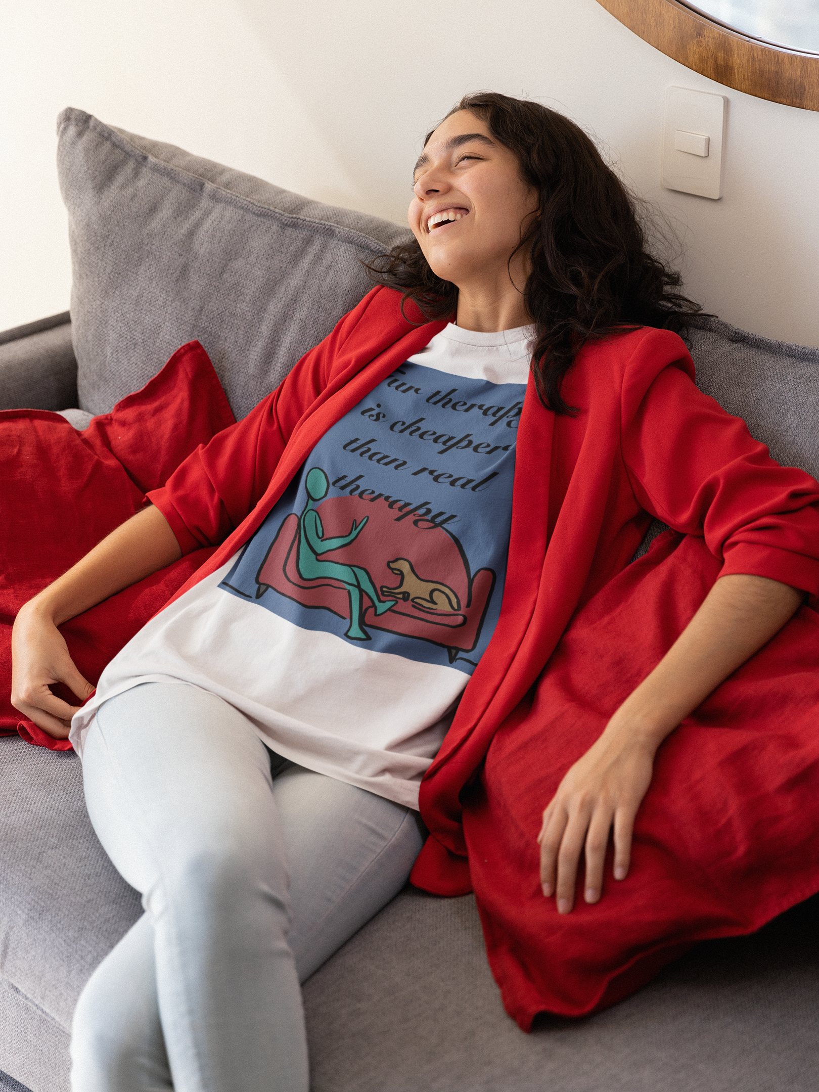 Woman in red jacket relaxing on couch wearing white Fur Therapy Is Cheaper Than Real Therapy colored dog t-shirt – funny pet therapy design by GrungePup Sarcastic Affirmations