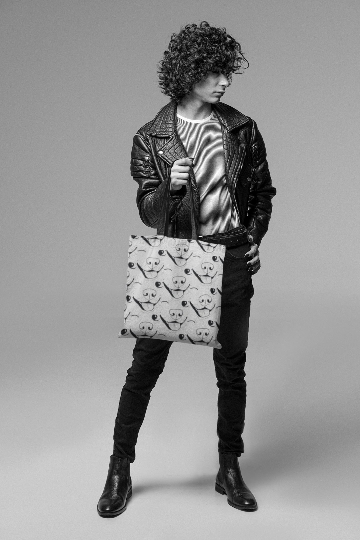 Man wearing black and white outfit carrying GrungePup logo all-over print tote bag