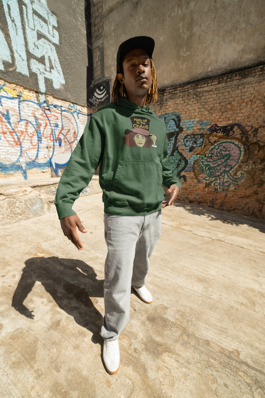 Man in a black cap and forest green Hats Off to the Chaos Mad Hatter hoodie standing in a graffiti alley. That Girl, Alice by GrungePup Gallery.