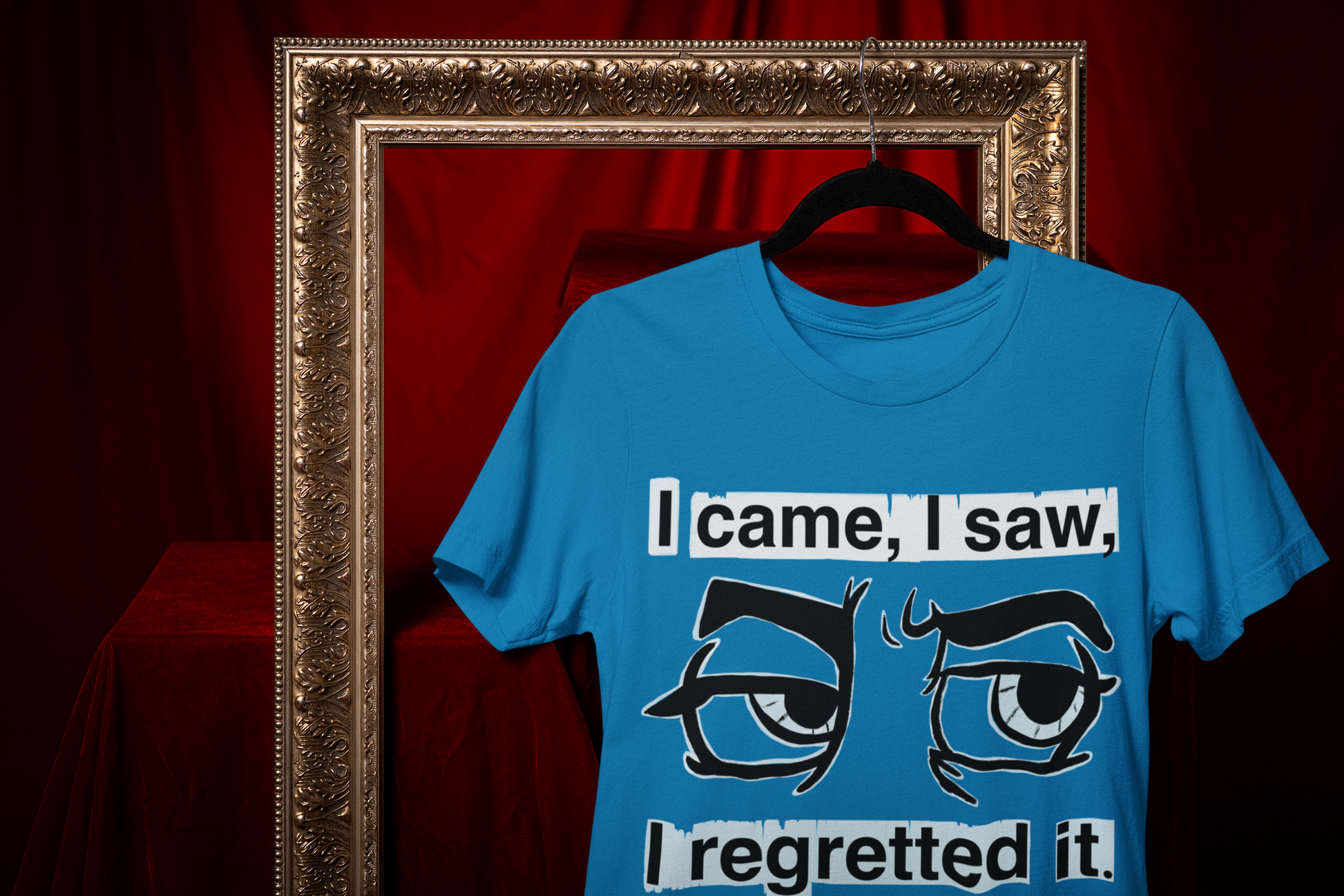 Sapphire blue Gildan Softstyle t-shirt with I Came I Saw I Regretted It eye-roll design hanging on a black hanger