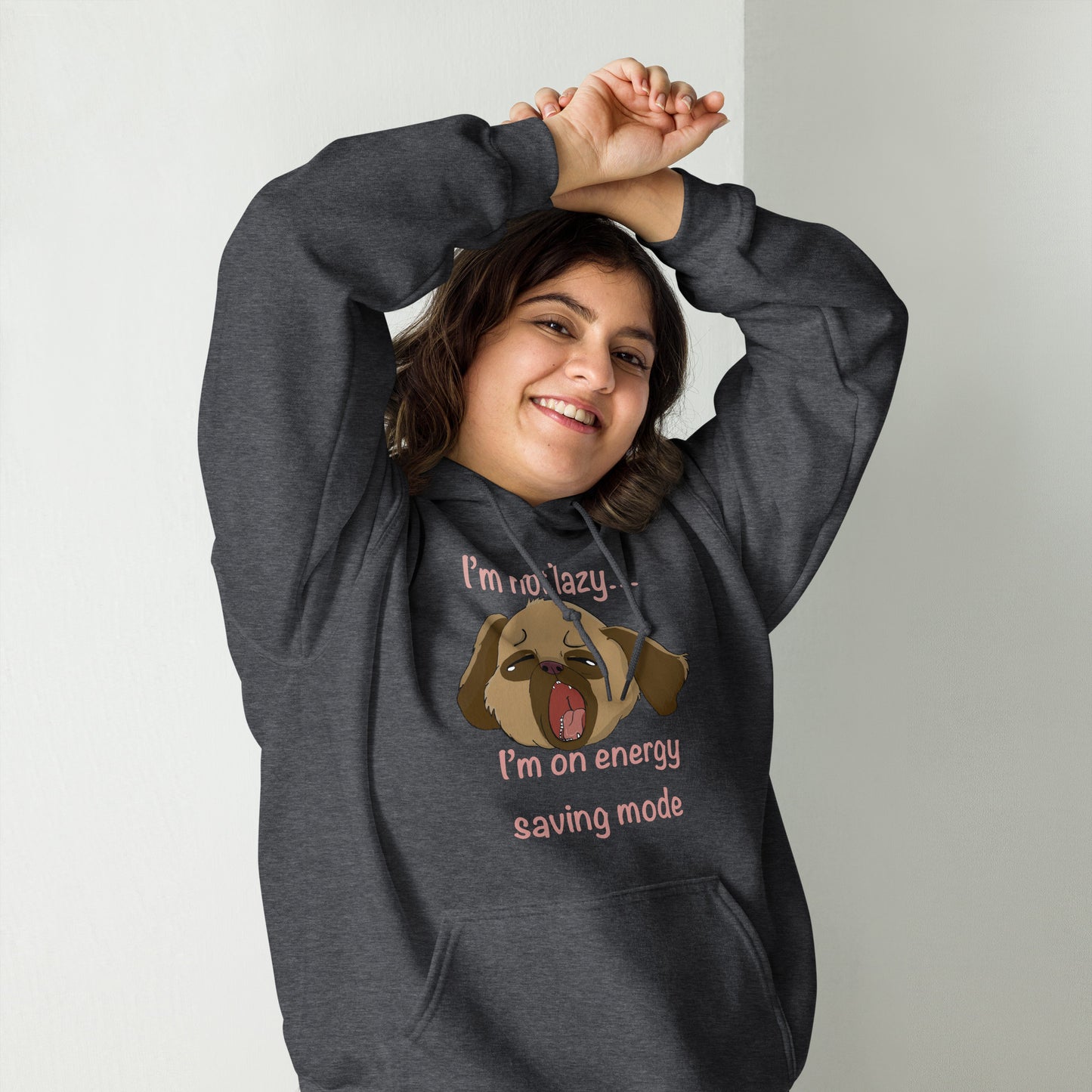 Woman with dark hair stretching with hands over head while wearing dark heather I'm Not Lazy... I'm On Energy Saving Mode hoodie