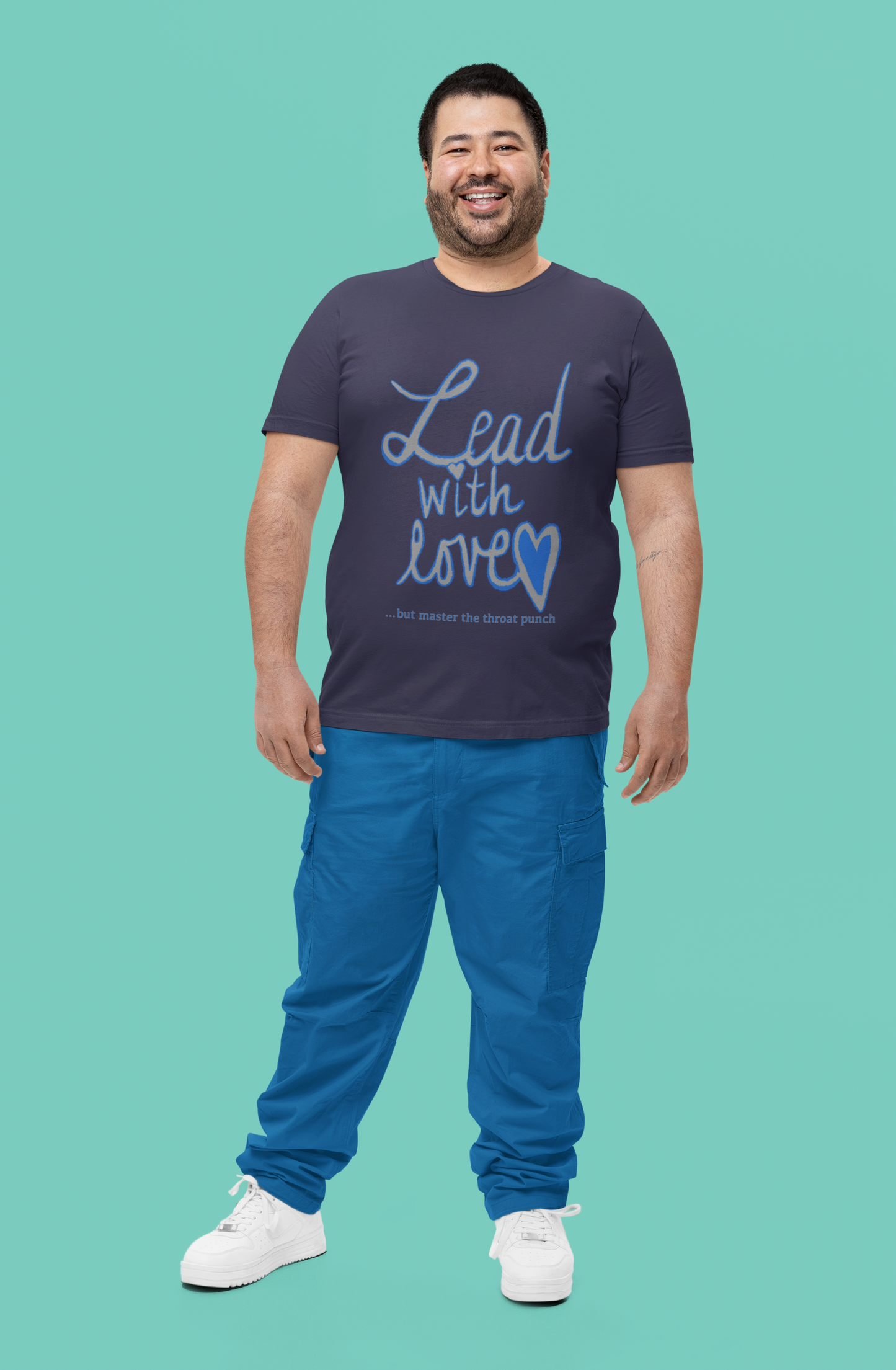 Bearded man smiling in heather midnight navy Bella Canvas t-shirt featuring "Lead with Love… but master the throat punch" sarcastic self-care design. Strong yet heartfelt message for men who protect their peace.