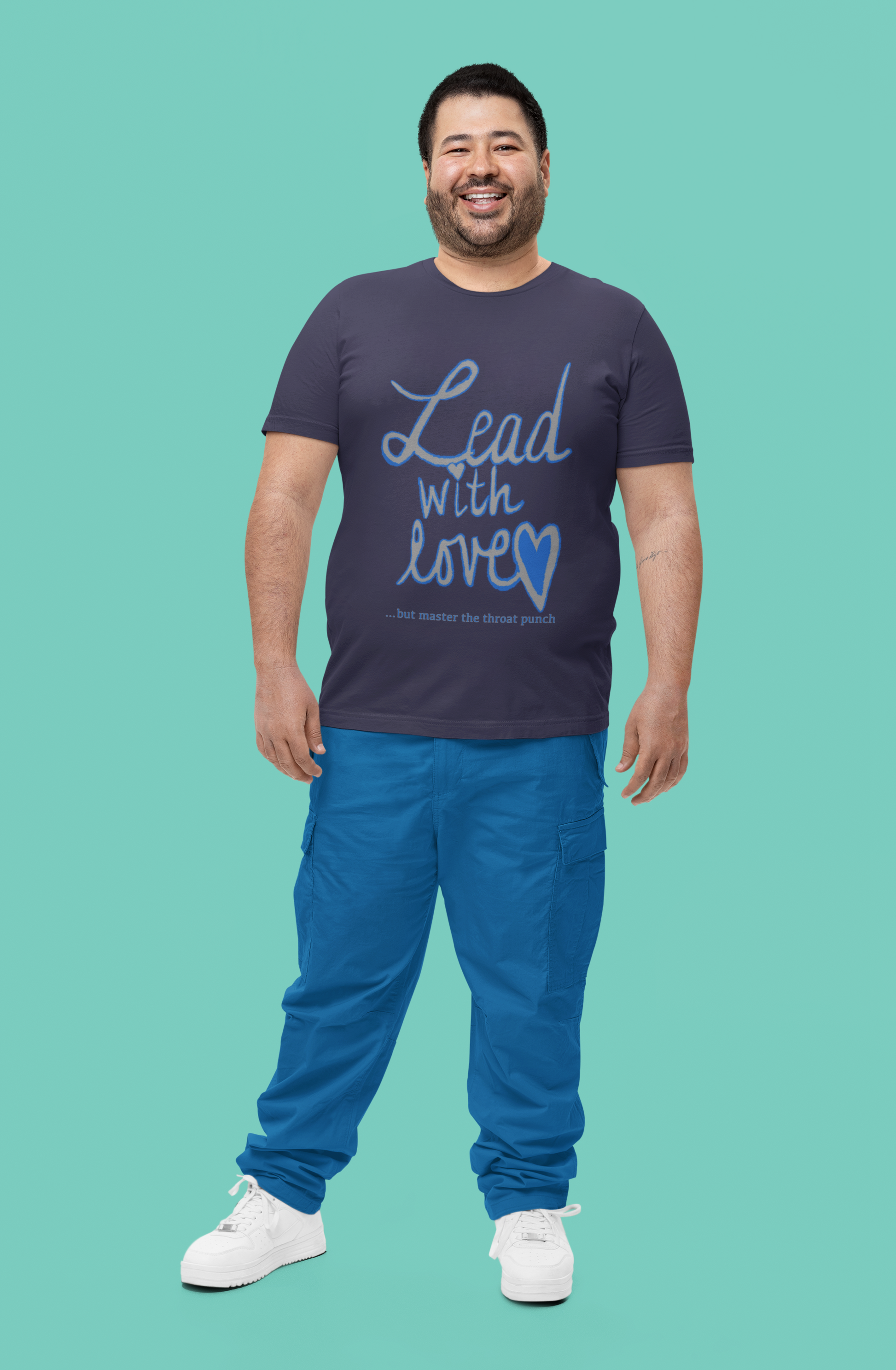 Bearded man smiling in heather midnight navy Bella Canvas t-shirt featuring "Lead with Love… but master the throat punch" sarcastic self-care design. Strong yet heartfelt message for men who protect their peace.