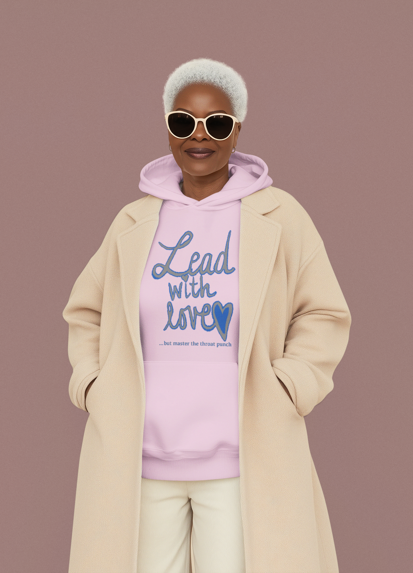 Woman in pink t-shirt holding hairbrush wearing "Lead with Love… but master the throat punch" sarcastic self-care design. Fun, empowering message for kind but boundary-strong individuals.