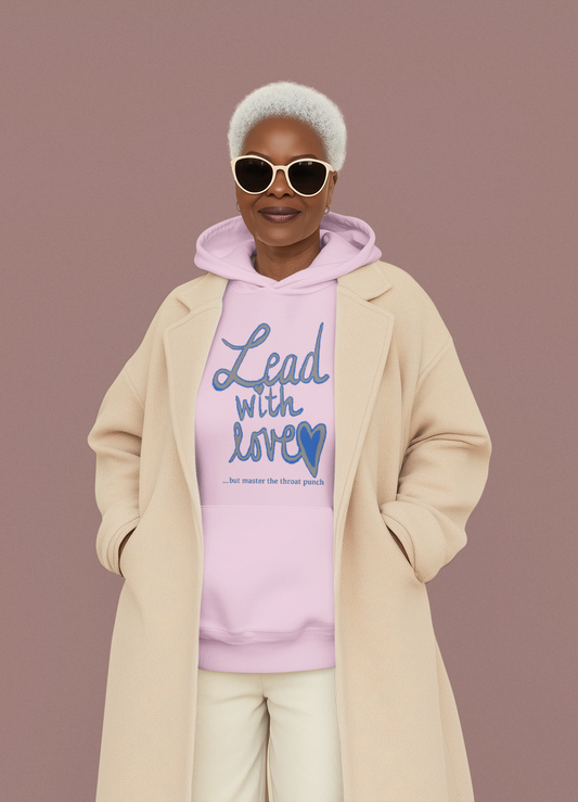 Woman in pink t-shirt holding hairbrush wearing "Lead with Love… but master the throat punch" sarcastic self-care design. Fun, empowering message for kind but boundary-strong individuals.