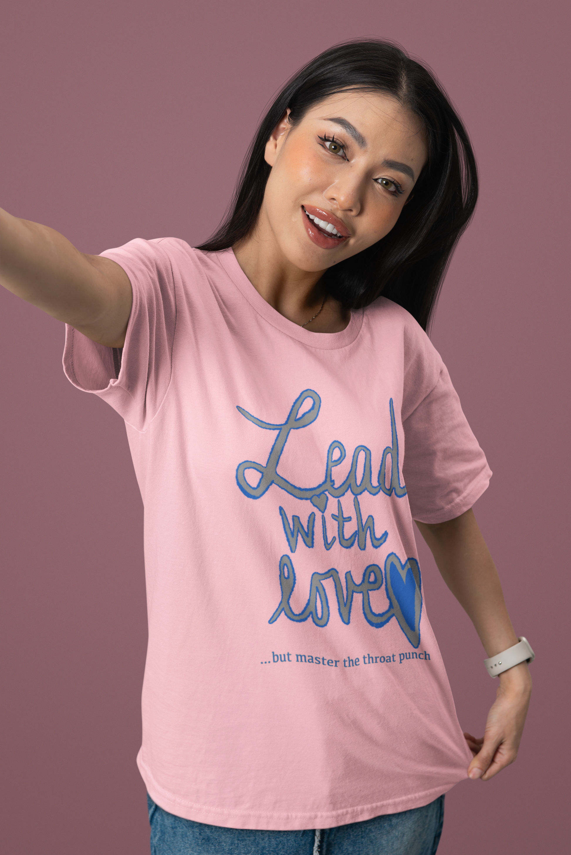 Happy woman in pink Bella Canvas t-shirt featuring "Lead with Love… but master the throat punch" sarcastic self-care graphic. Fun and empowering design for those who lead with kindness but protect their peace.