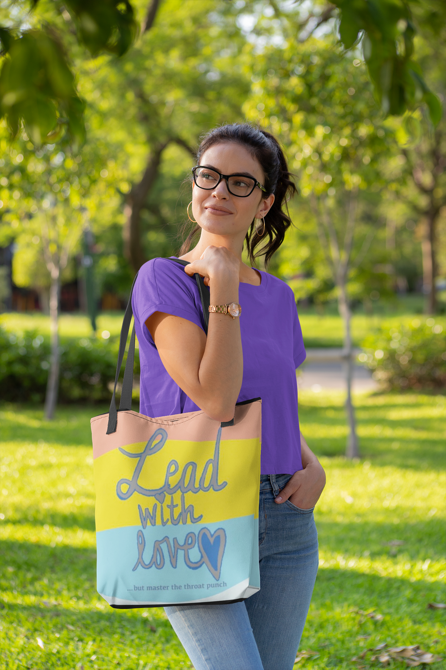 Woman in purple shirt carrying all-over print tote bag featuring "Lead with Love… but master the throat punch" sarcastic self-care design. Bold empowering message for kind hearts with strong boundaries. Part of GrungePup Sarcastic Self-Care collection.