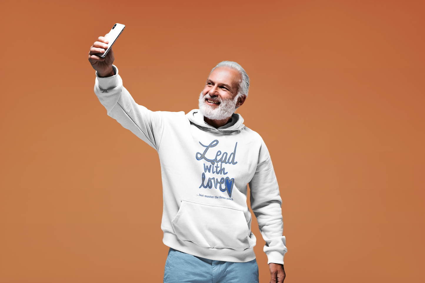 Man taking selfie in white Gildan 18500 hoodie with "Lead with Love… but master the throat punch" sarcastic design. Unisex self-care humor for strong boundaries and soft hearts.