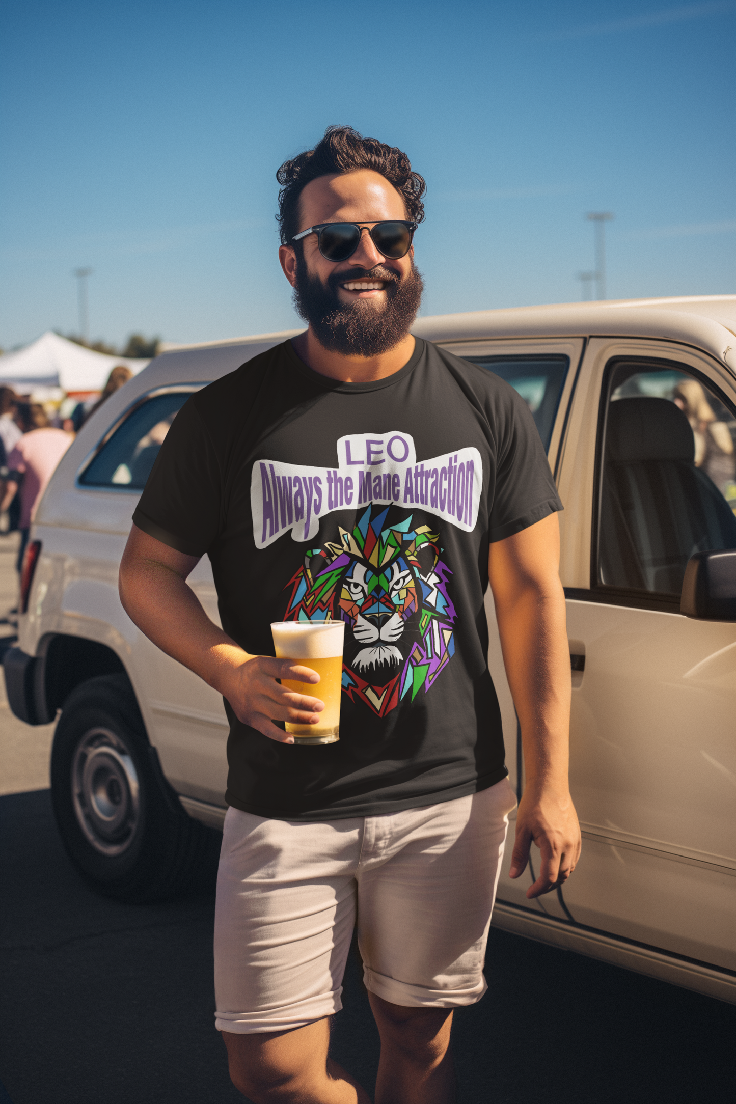 Bearded man in sunglasses smiling while holding a beer at a tailgate party, wearing a black heather Leo Always the Mane Attraction t-shirt