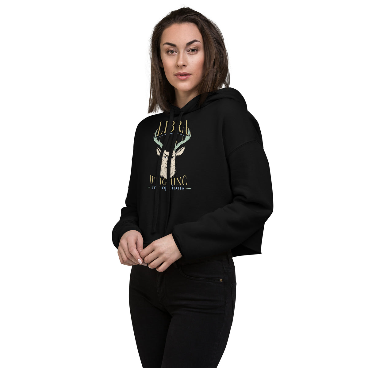 Woman wearing a black cropped Libra Weighing My Options hoodie with cream stag, mint antlers, and gold lettering.