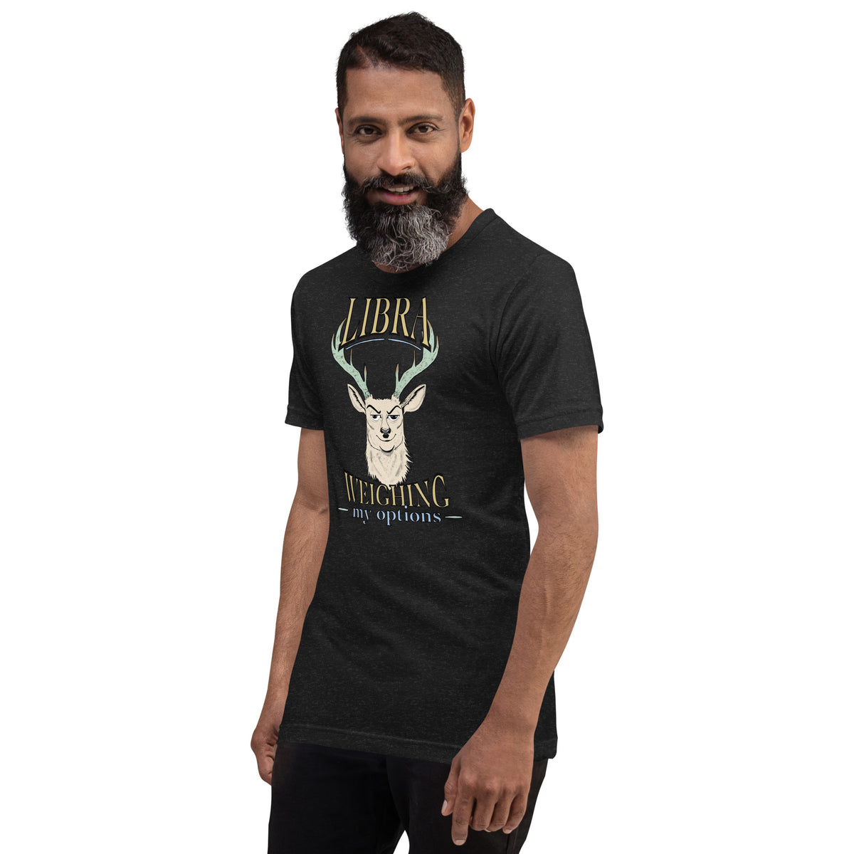 Bearded man wearing a black heather Libra Weighing My Options unisex tee with cream stag, mint antlers, and gold lettering.