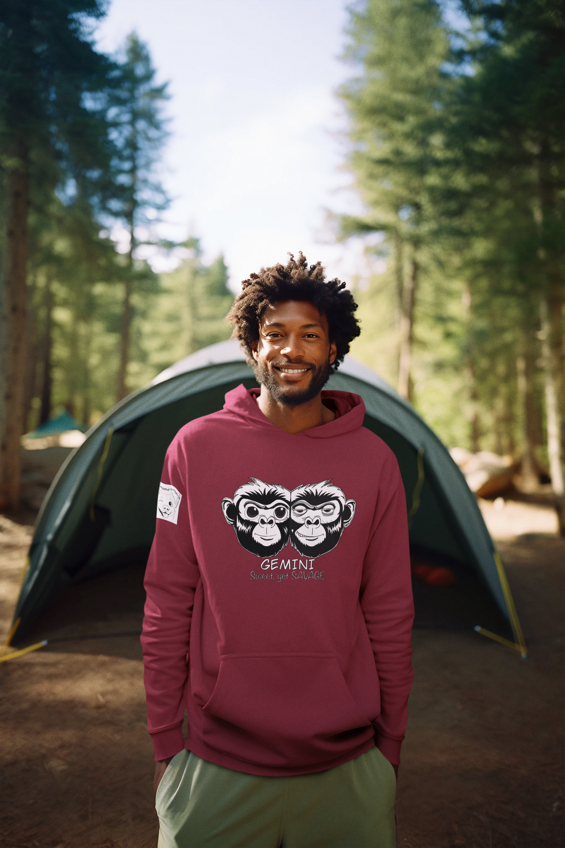 Man smiling in front of a camping tent wearing a maroon Gemini hoodie