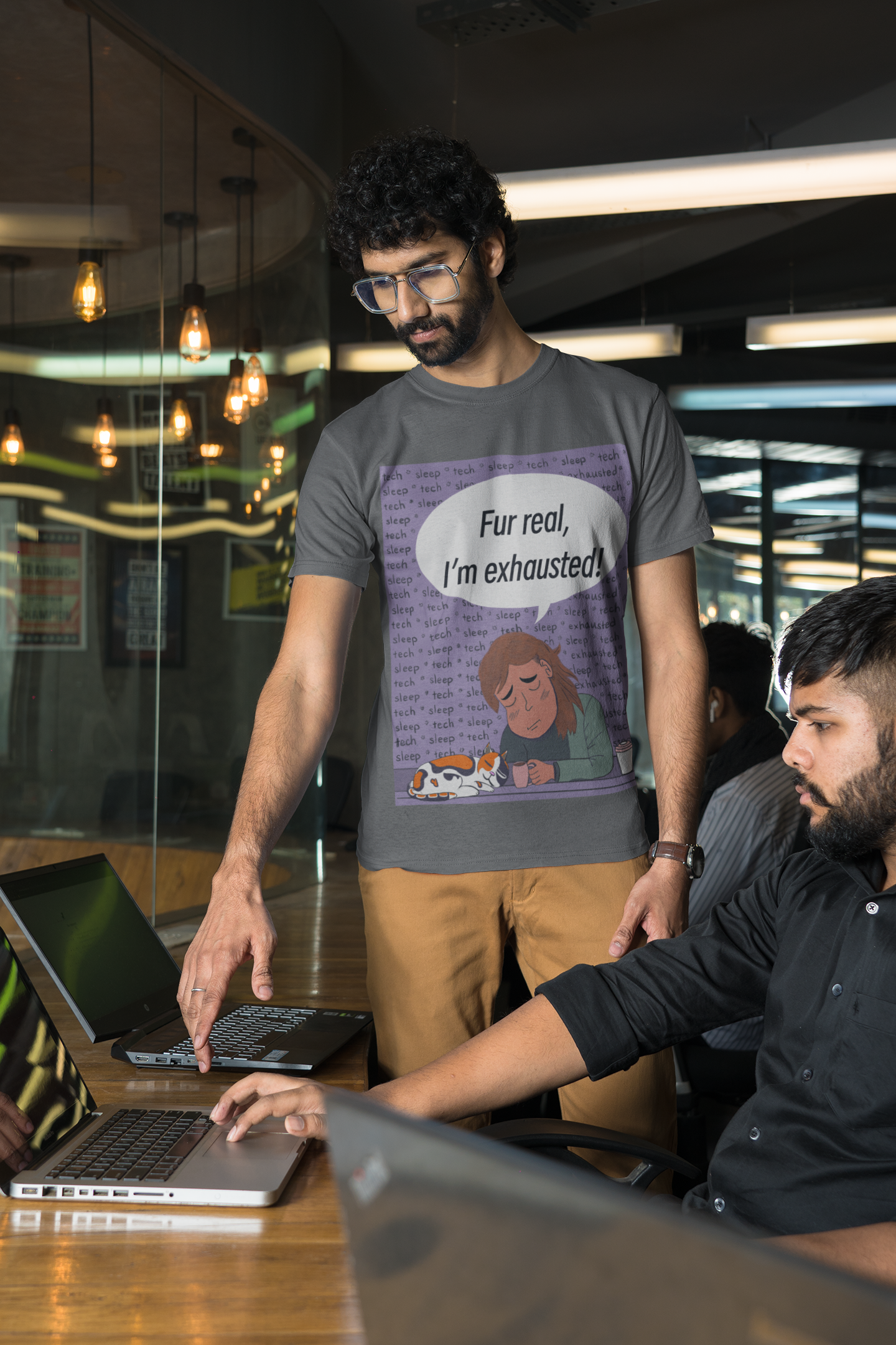 Man with glasses wearing a dark heather grey Fur Real, I'm Exhausted t-shirt in an office setting