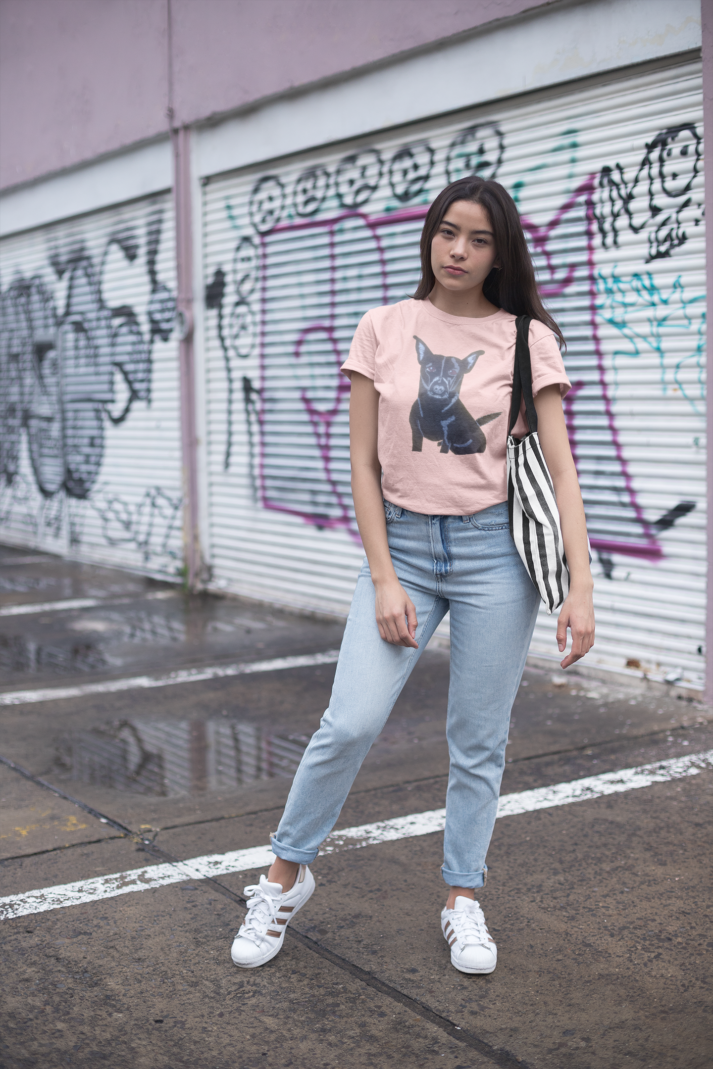Woman standing in front of graffiti wall wearing light pink Mathis Pet Portrait t-shirt