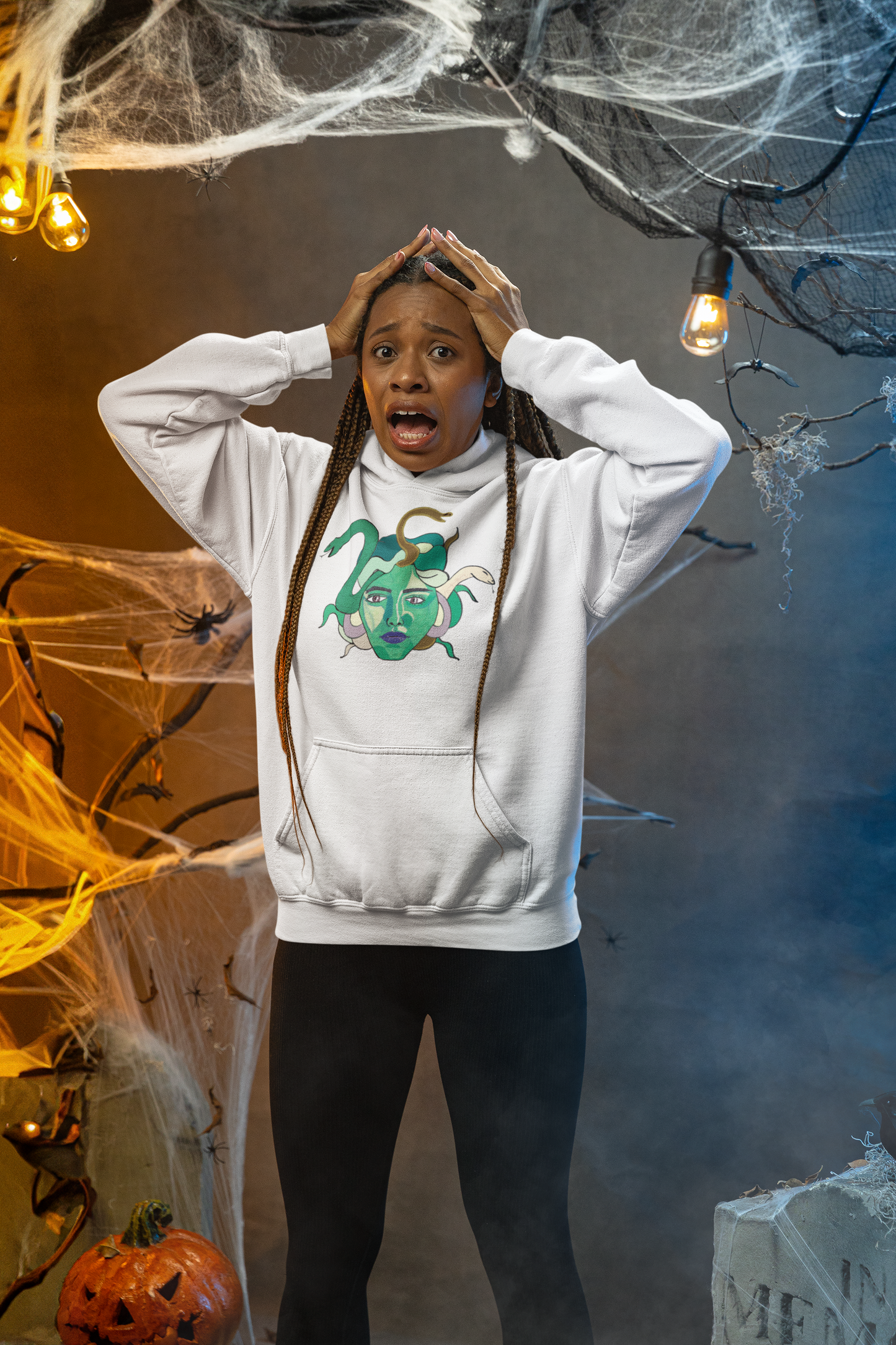 Woman looking startled in a haunted house set, wearing a white Medusa hoodie by GrungePup Gallery