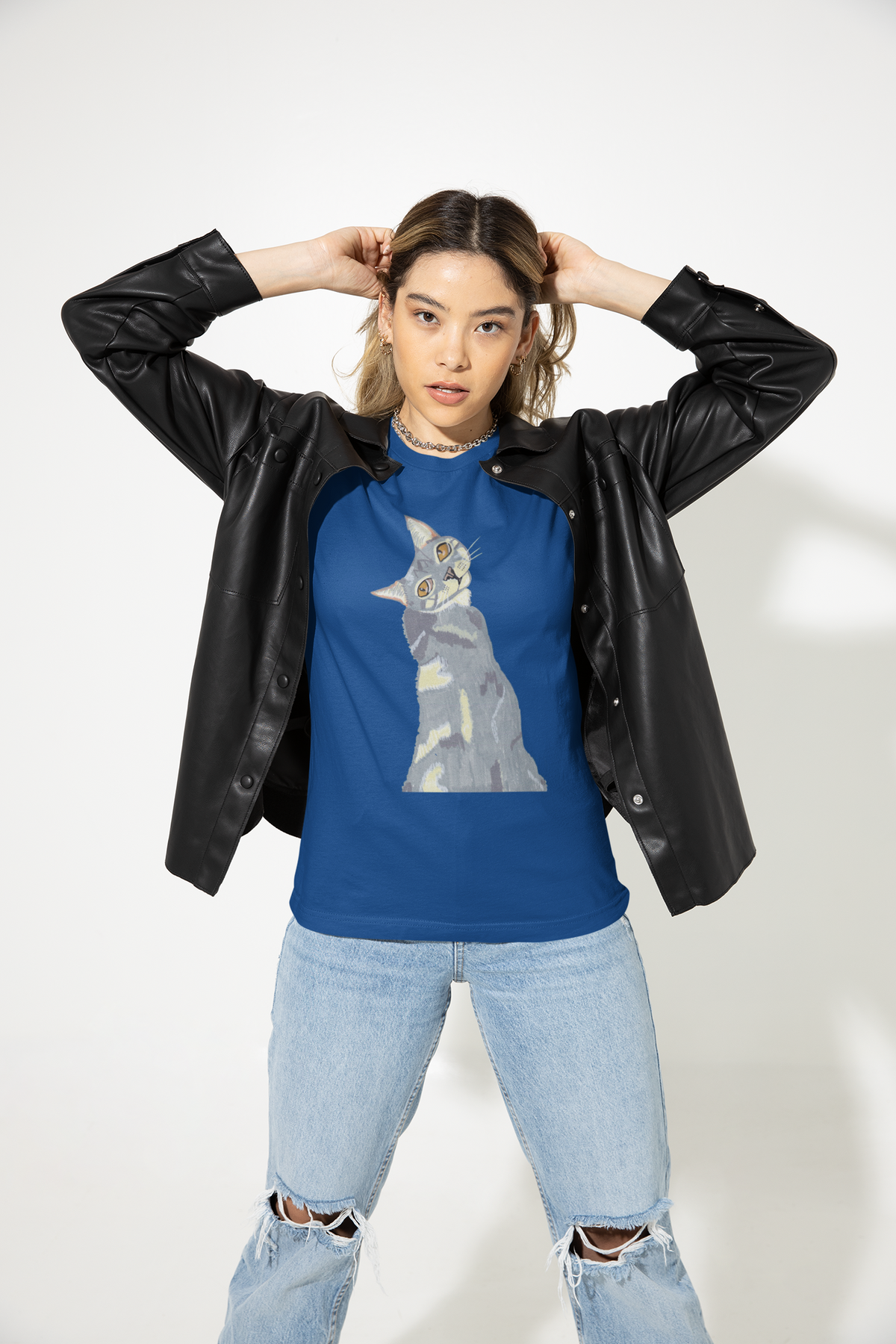 Woman in a black leather jacket with hands behind her head, wearing the Mr. Grey Cat Portrait T-Shirt in true royal blue.