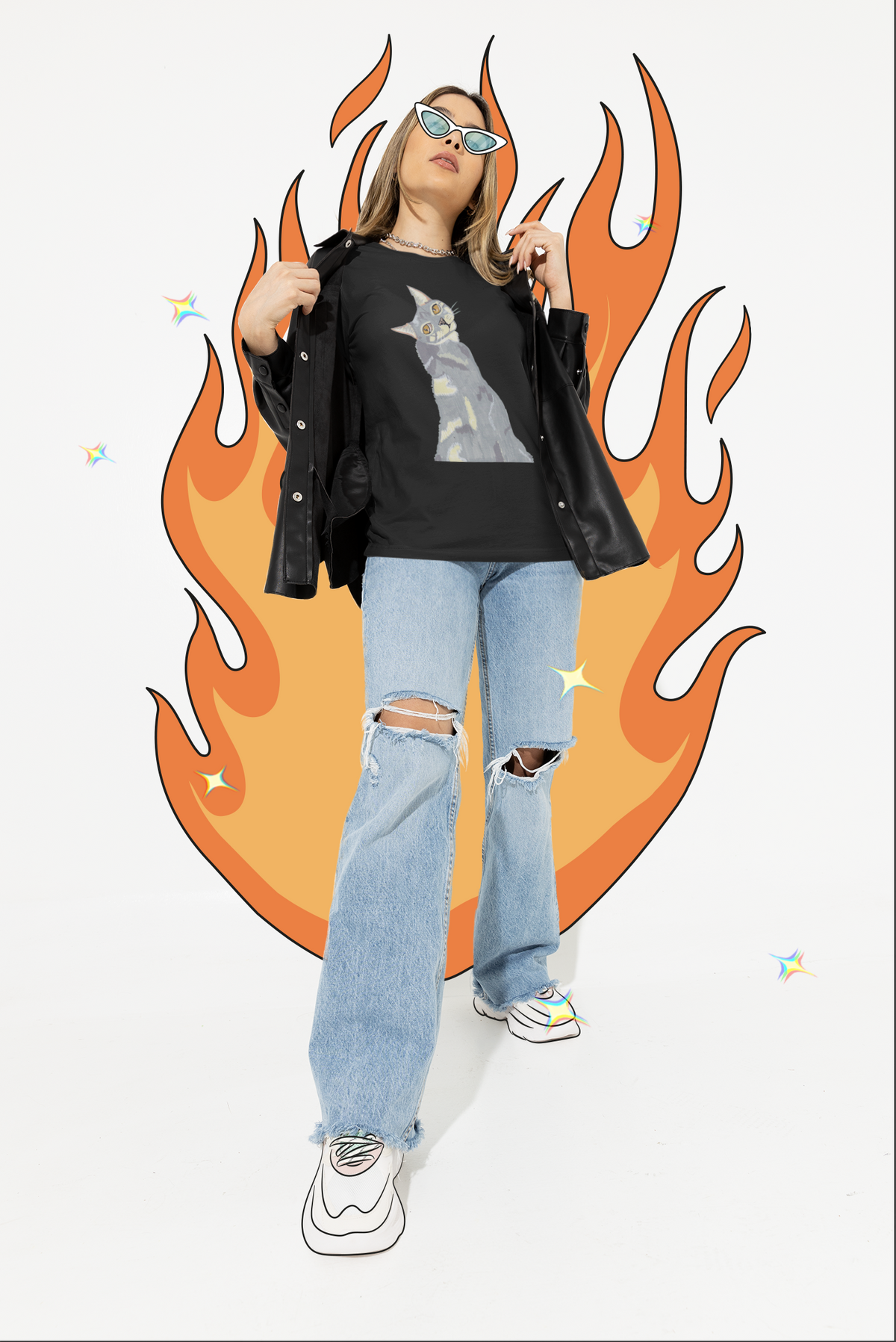 Woman in a black leather jacket and ripped jeans wearing the Mr. Grey Cat Portrait T-Shirt in black, standing against a flame graphic background.