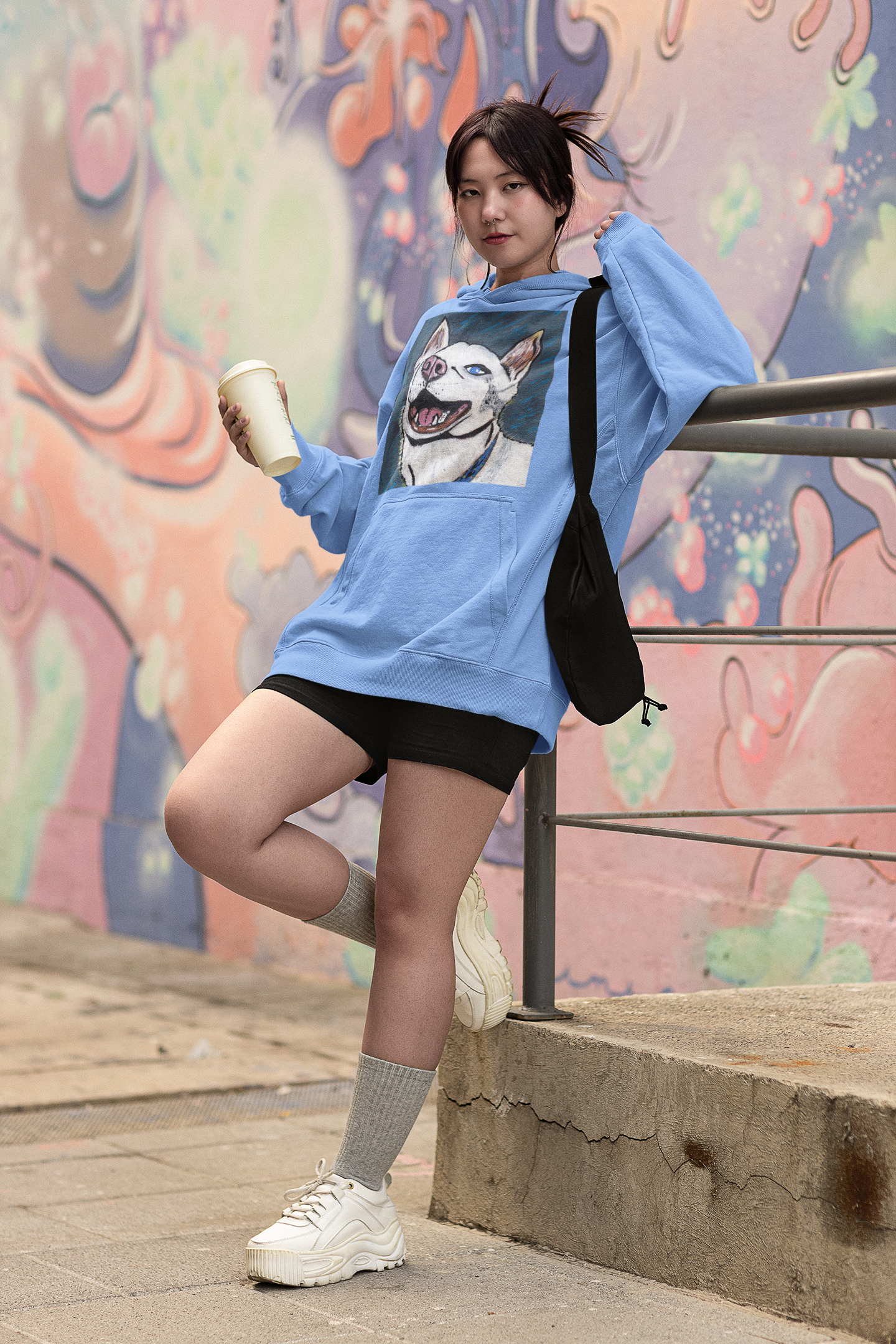 Woman wearing carolina blue Nico Face hoodie with colorful husky portrait