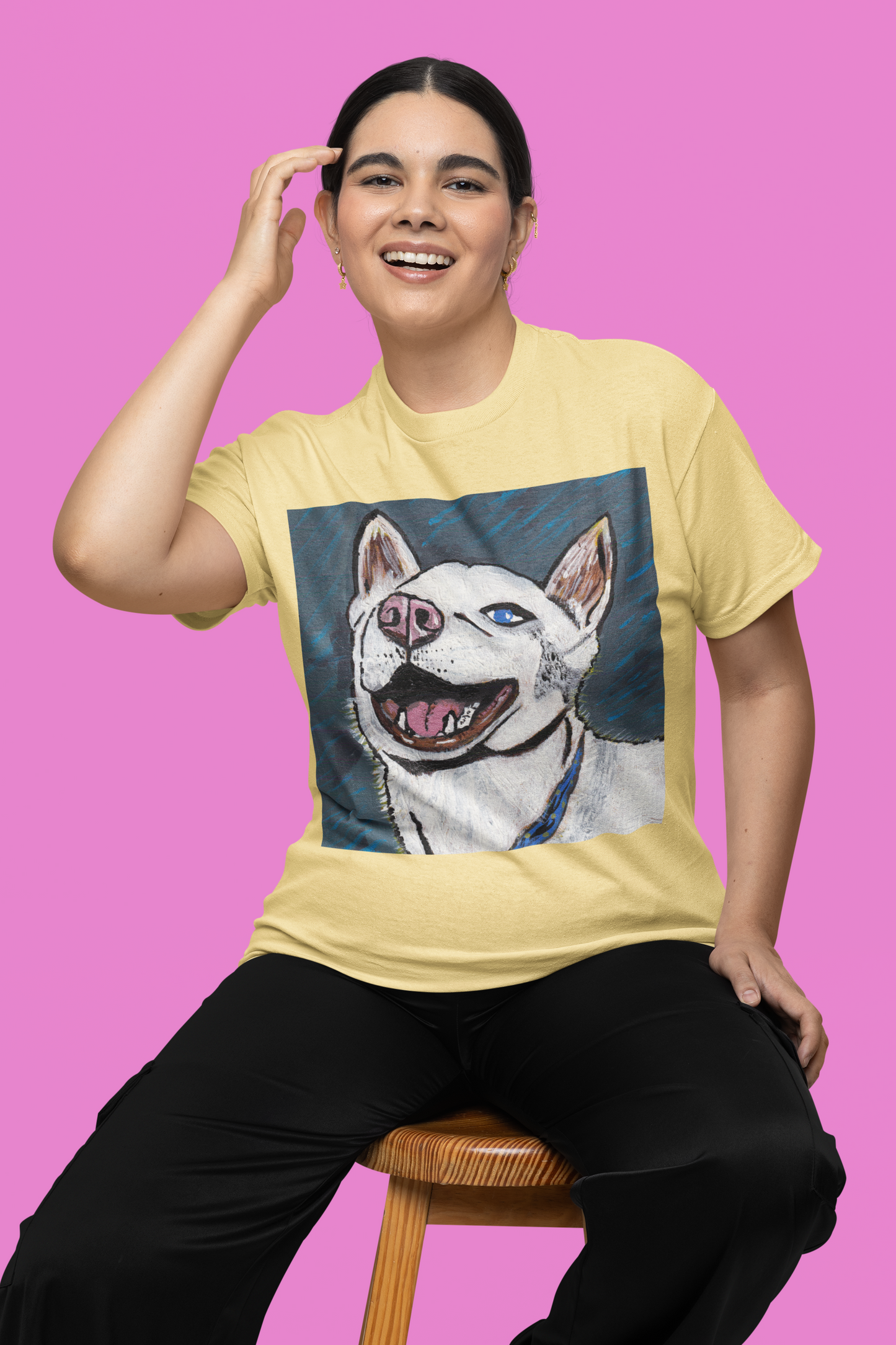 Woman sitting on stool wearing cornsilk yellow Nico Face t-shirt with colorful husky design