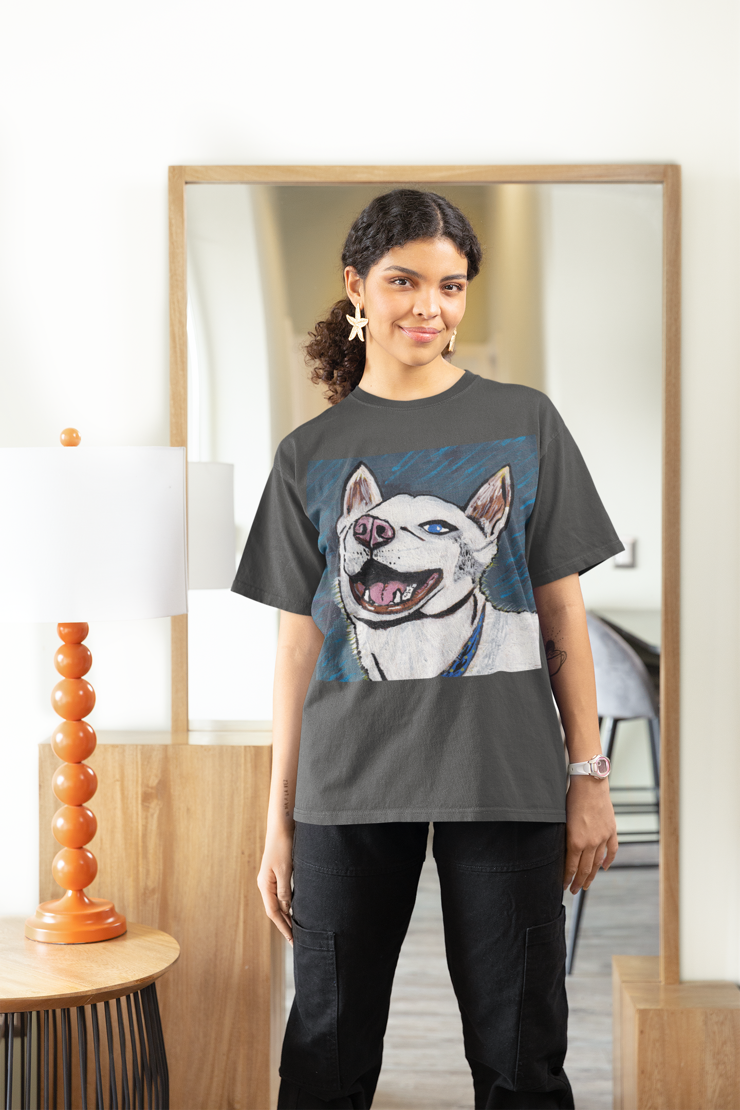 Woman standing by mirror wearing dark heather grey Nico Face t-shirt with husky art