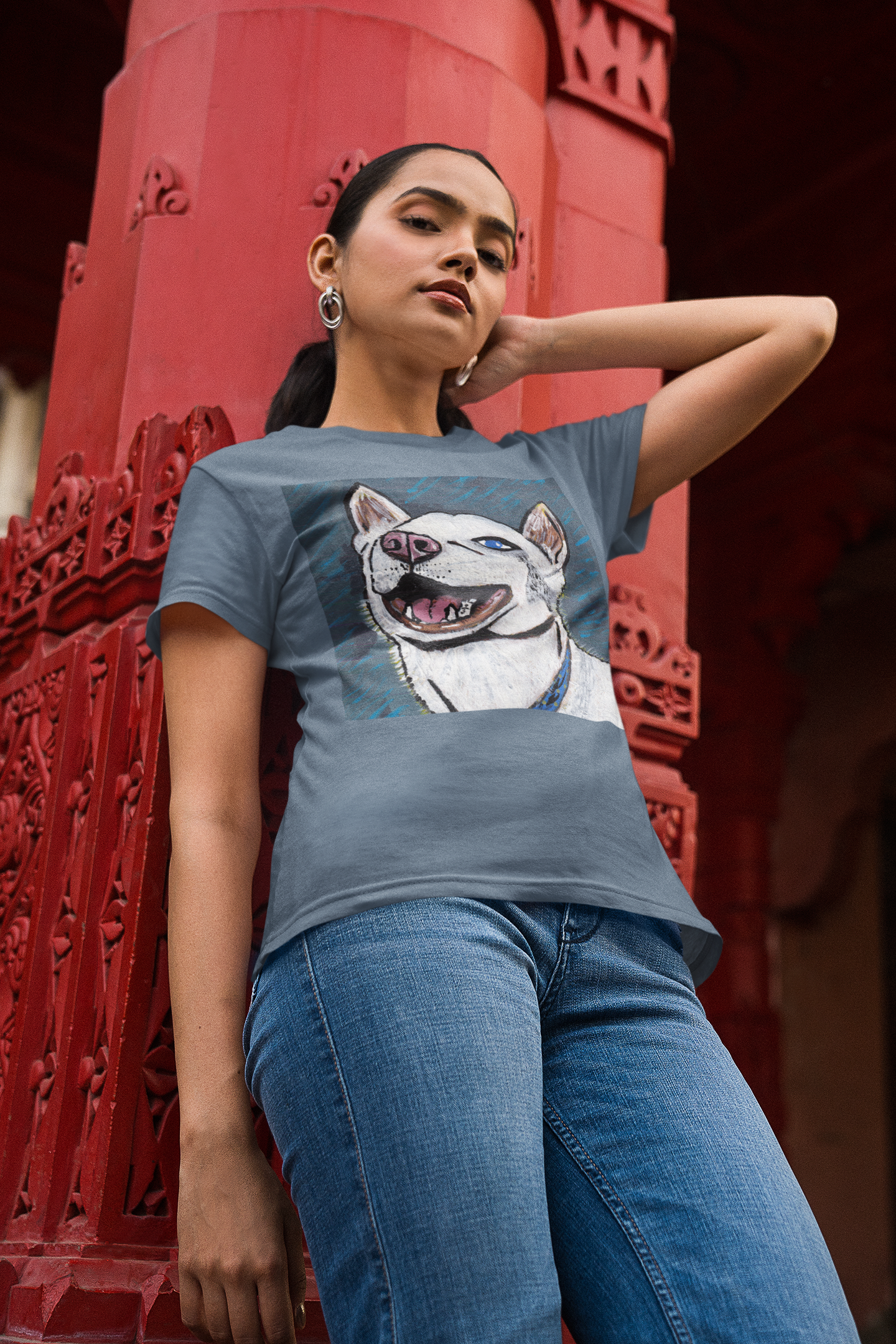 Woman leaning on red pillar wearing heather indigo Nico Face t-shirt