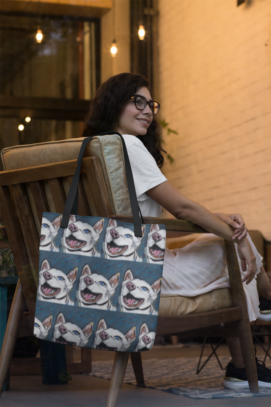 Woman sitting on couch with Nico Face all-over print tote bag featuring joyful husky portrait