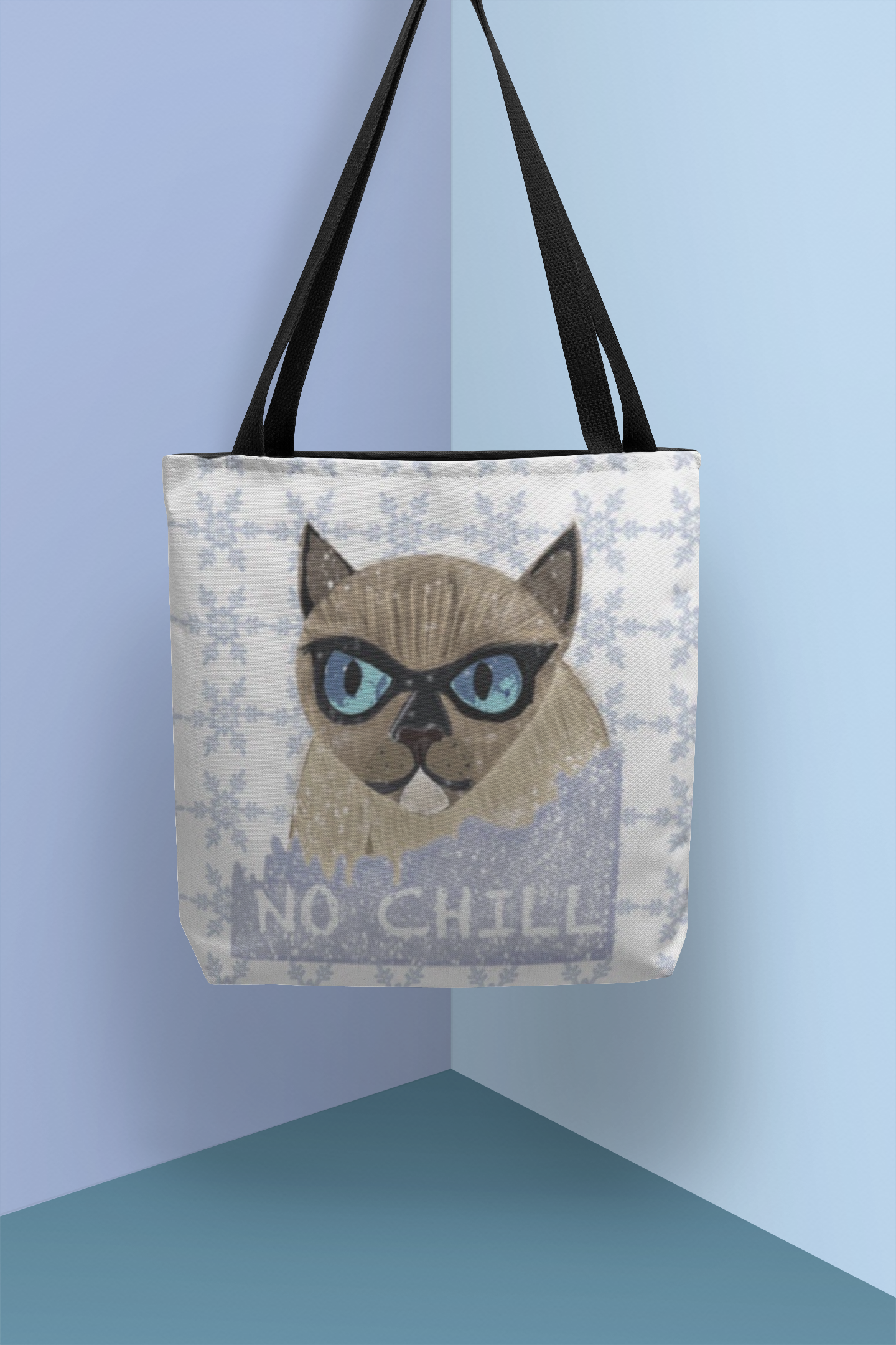No Chill Cat tote bag with snowflake pattern hanging in a blue corner showing full design
