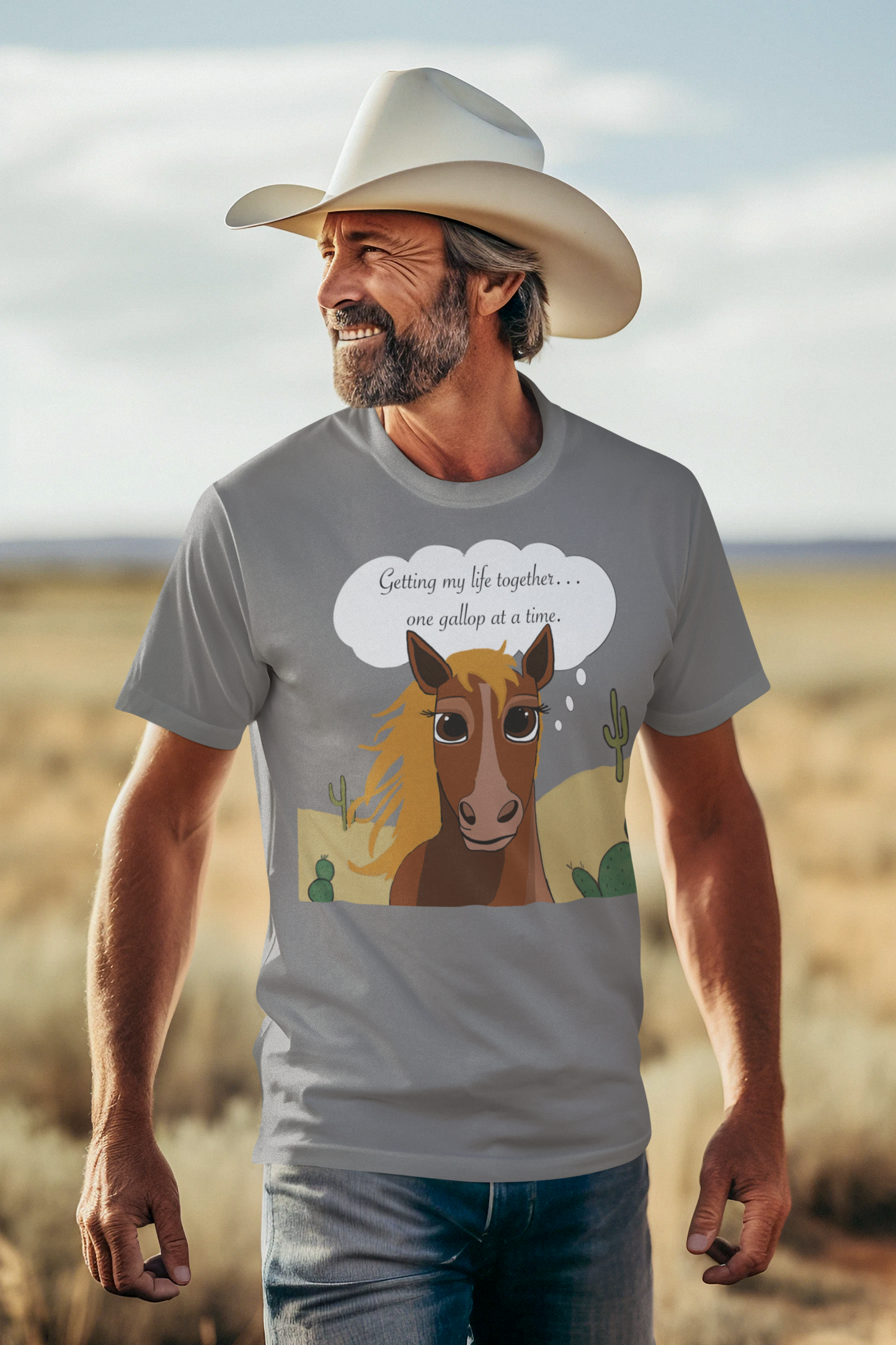 Man wearing cowboy hat and graphite heather One Gallop at a Time t-shirt smiling in desert setting