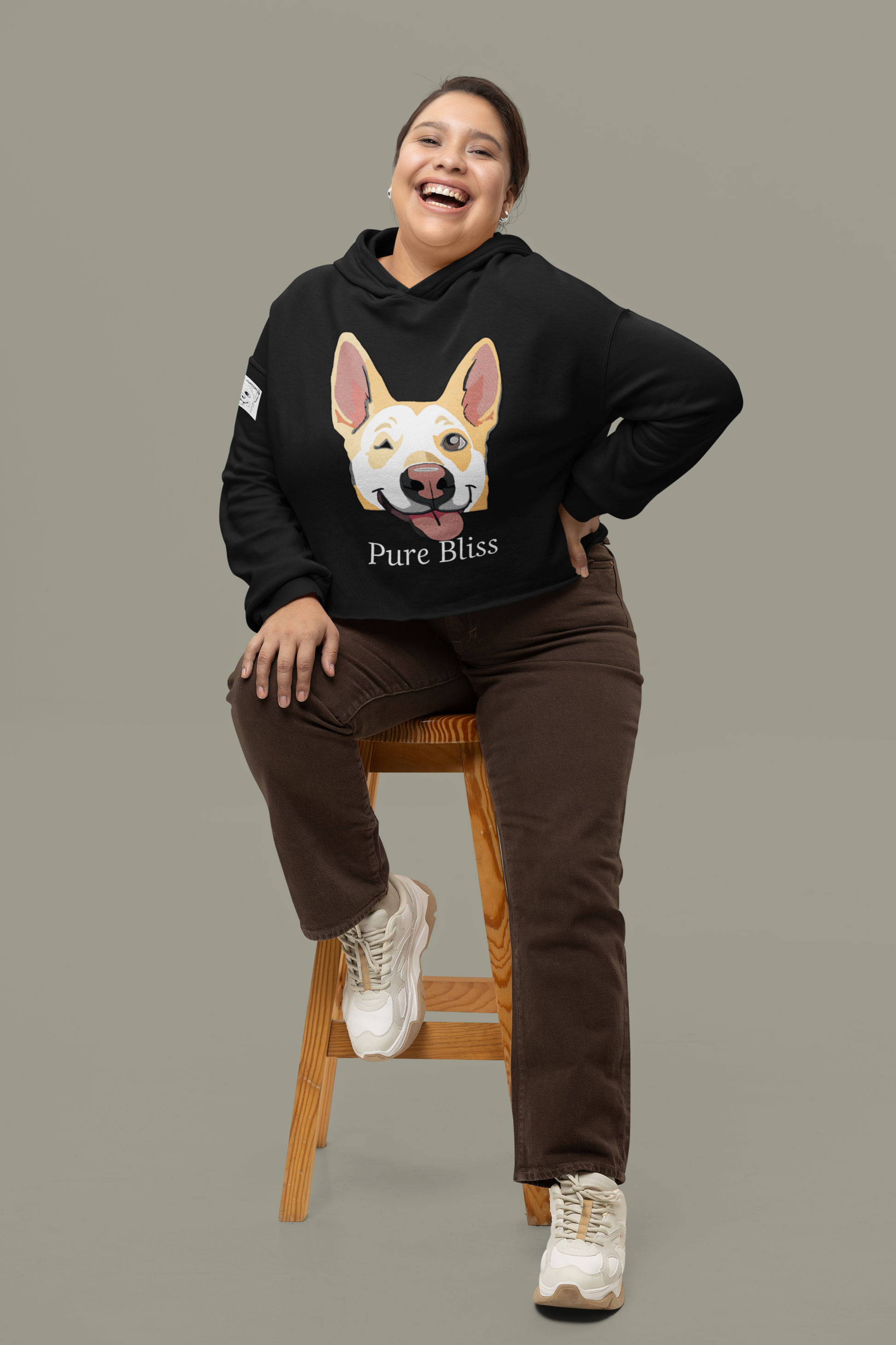Woman sitting on stool wearing black Pure Bliss Nico Face cropped hoodie