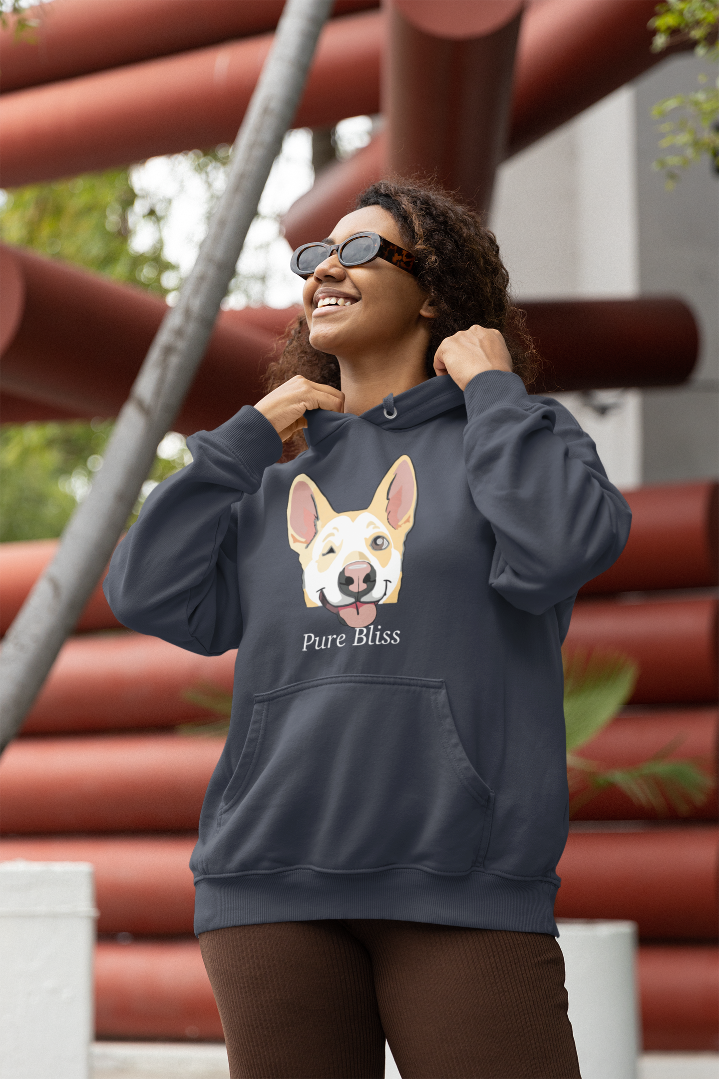 Woman smiling in front of colorful art piece wearing heather navy Pure Bliss Nico Face hoodie