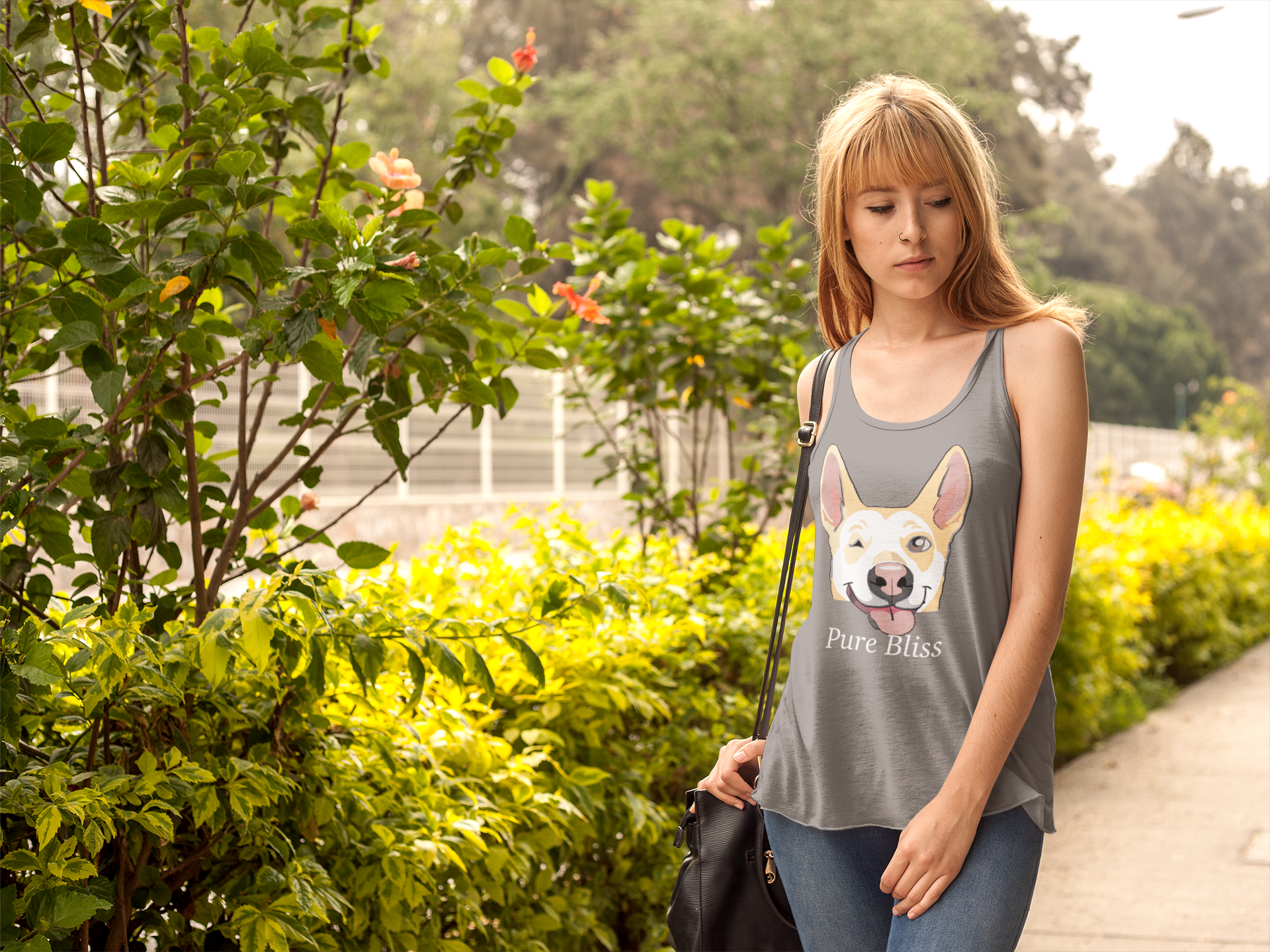 Woman standing in garden wearing premium heather gray Pure Bliss Nico Face racerback tank top