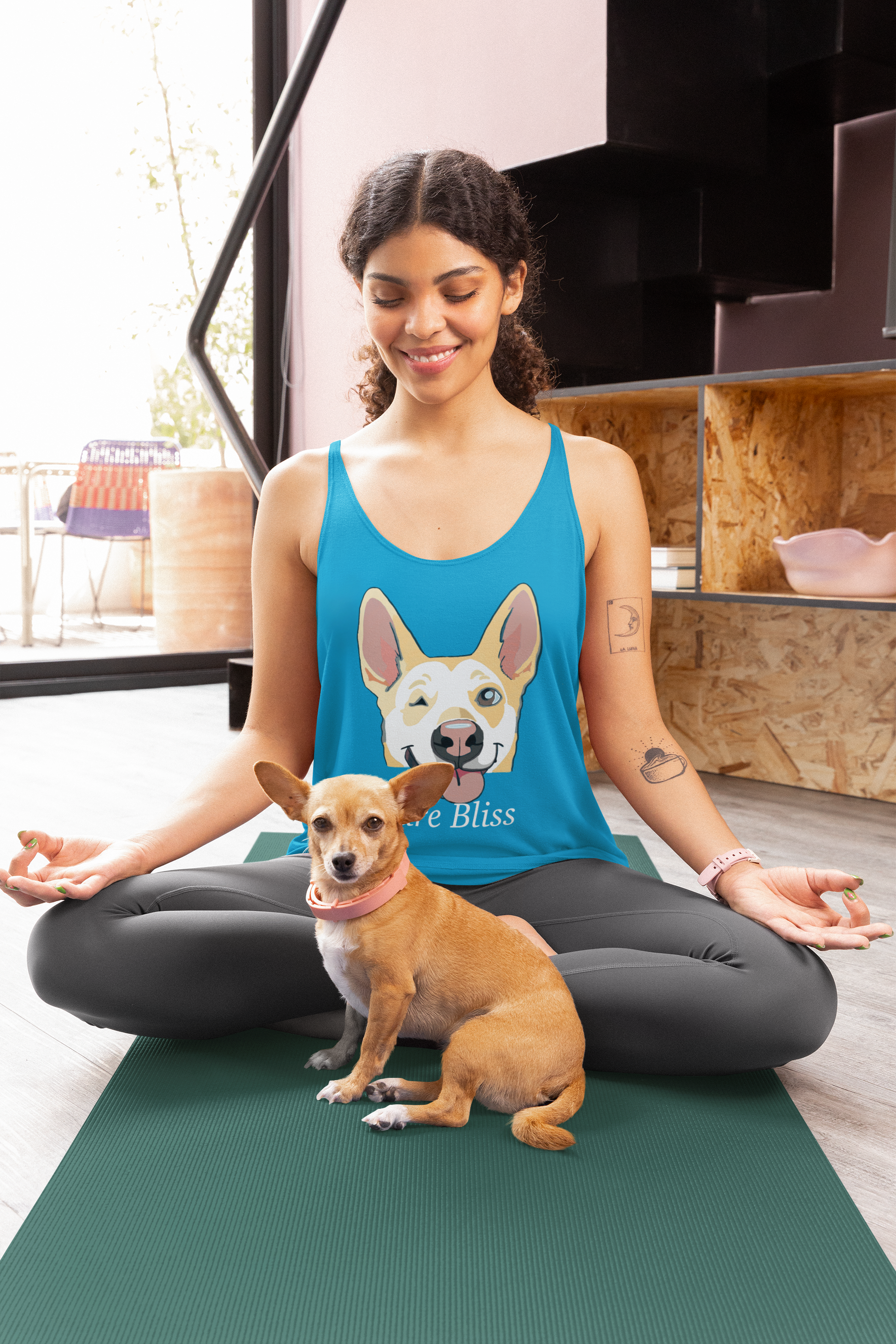 Woman sitting on yoga mat in meditation pose wearing vintage turquoise Pure Bliss Nico Face racerback tank top with small dog