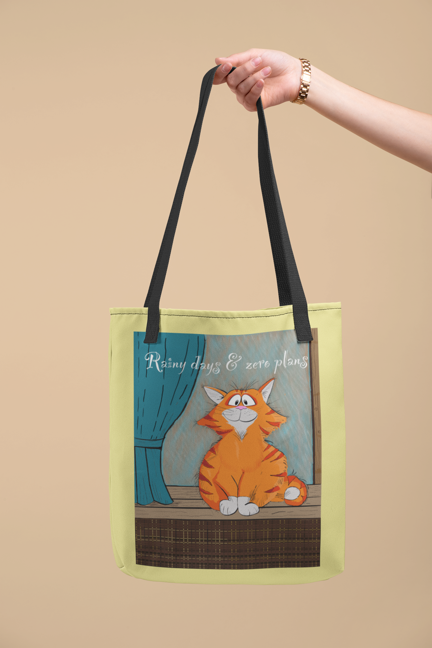 Hand holding lime green Rainy Days & Zero Plans cat tote bag with orange cat design and text "Rainy days & zero plans"